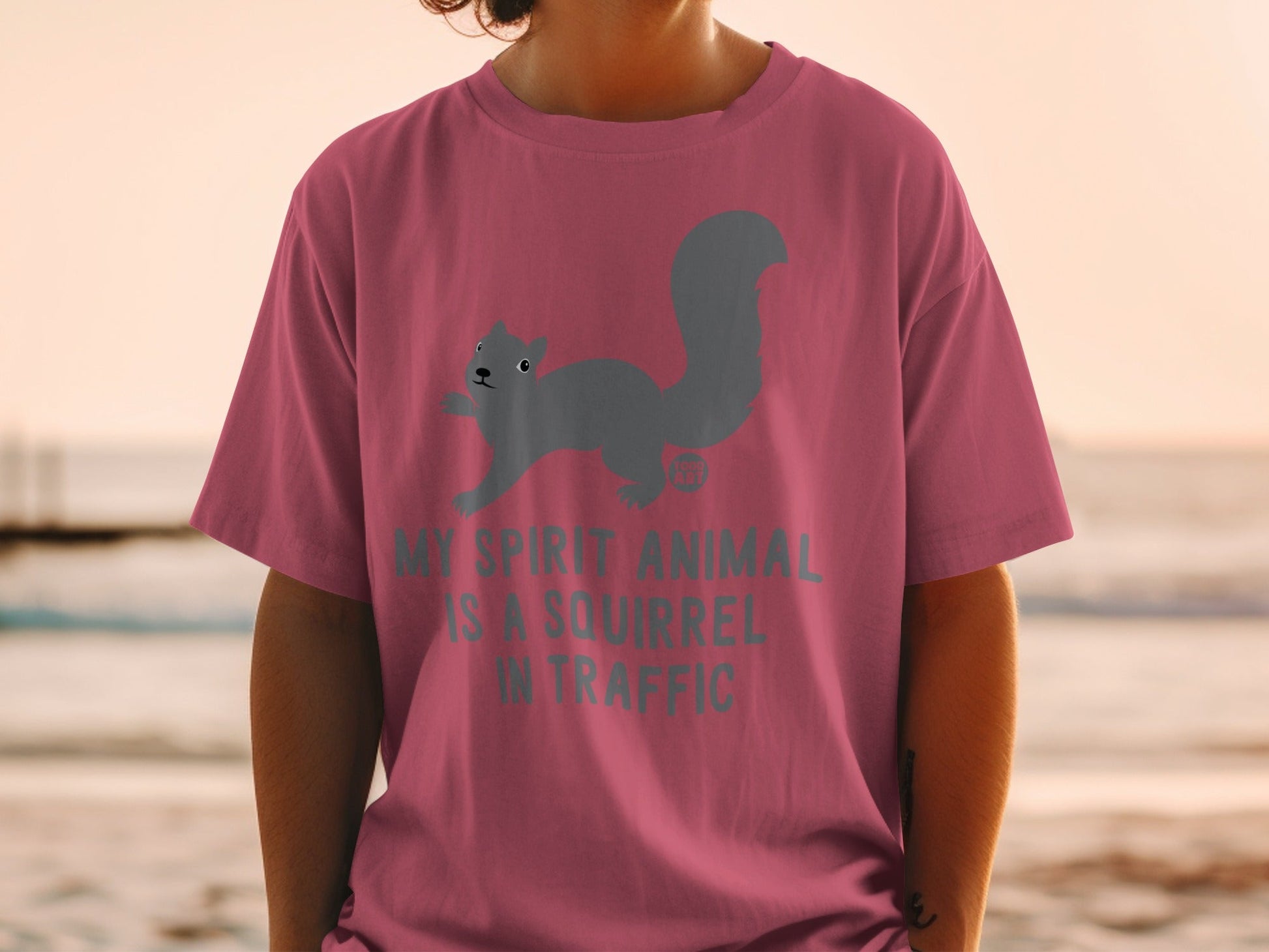 Pink t-shirt with gray squirrel graphic and "My spirit animal is a squirrel in traffic" text.