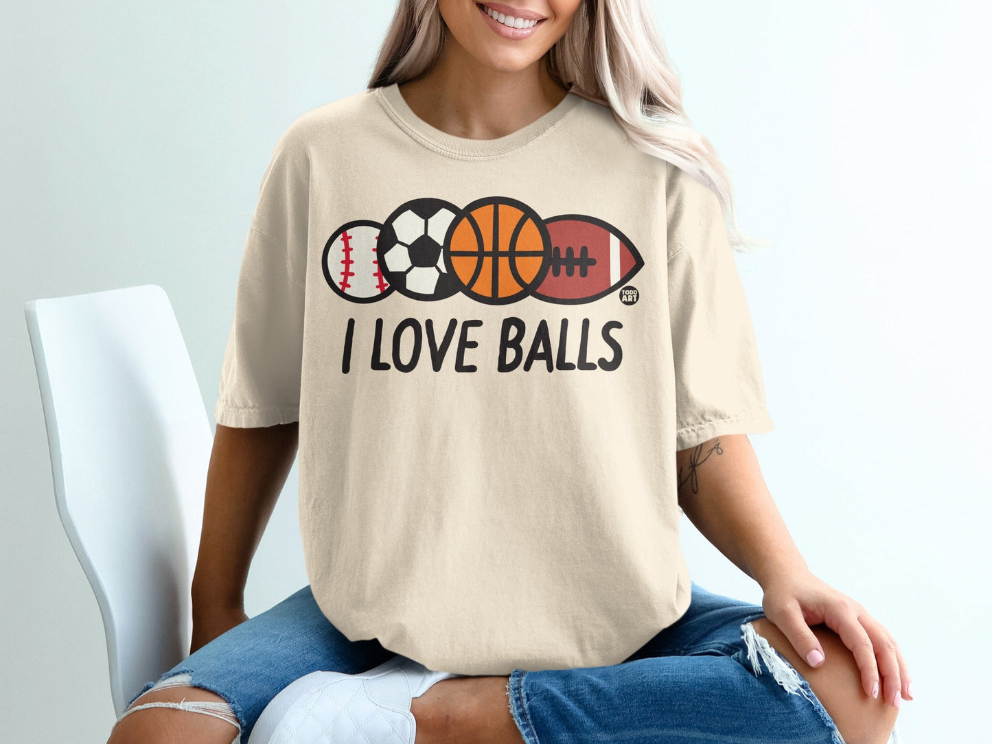 Cream t-shirt with "I Love Balls" and sports balls: baseball, soccer, basketball, football.
