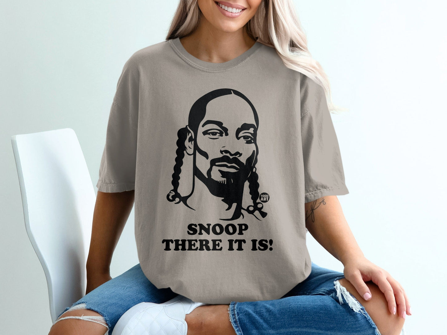 Snoop Dogg portrait with "SNOOP THERE IT IS!" text on a tan t-shirt.