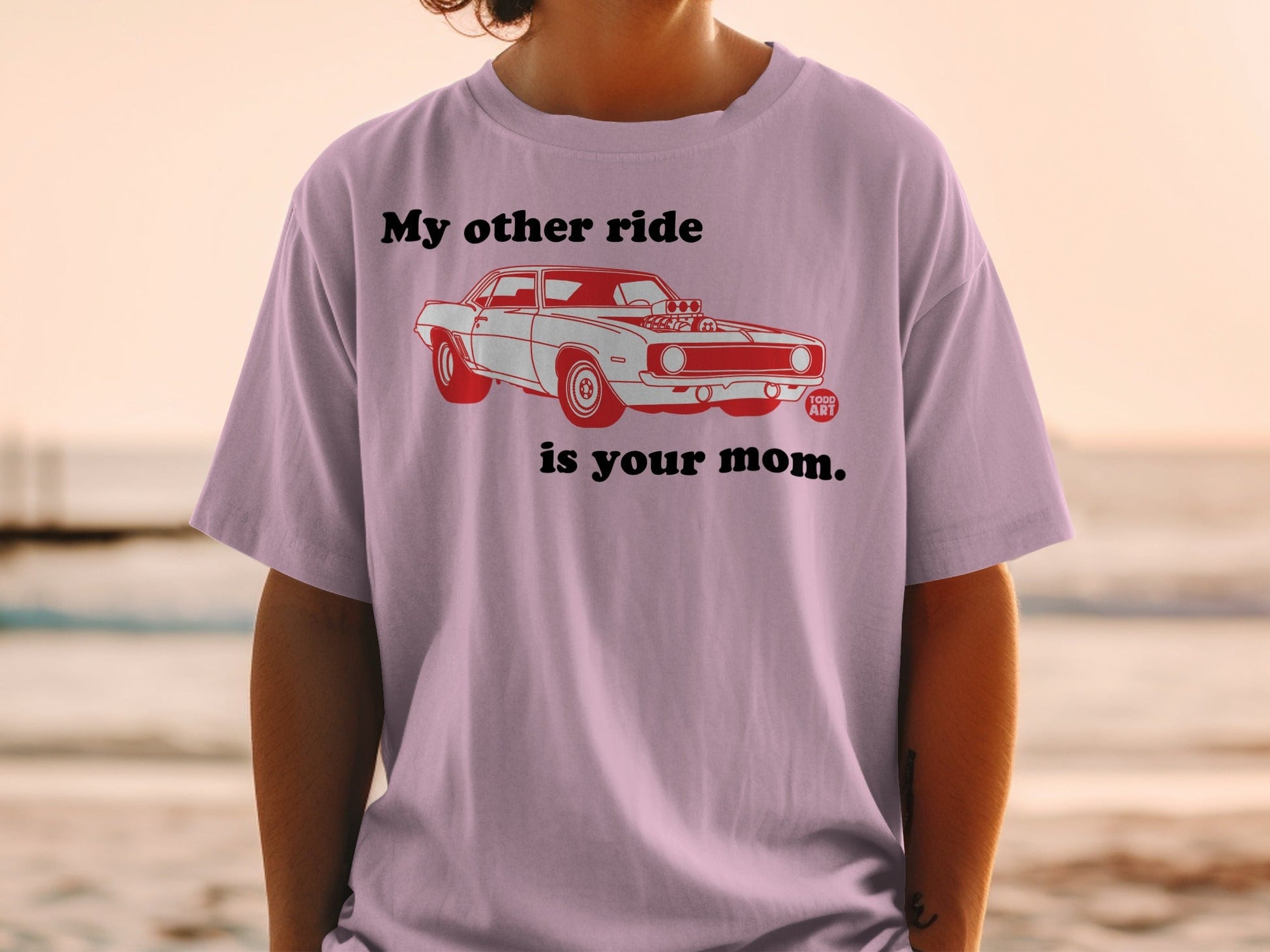 Light pink t-shirt with a red graphic of a classic car and text "My other ride is your mom."