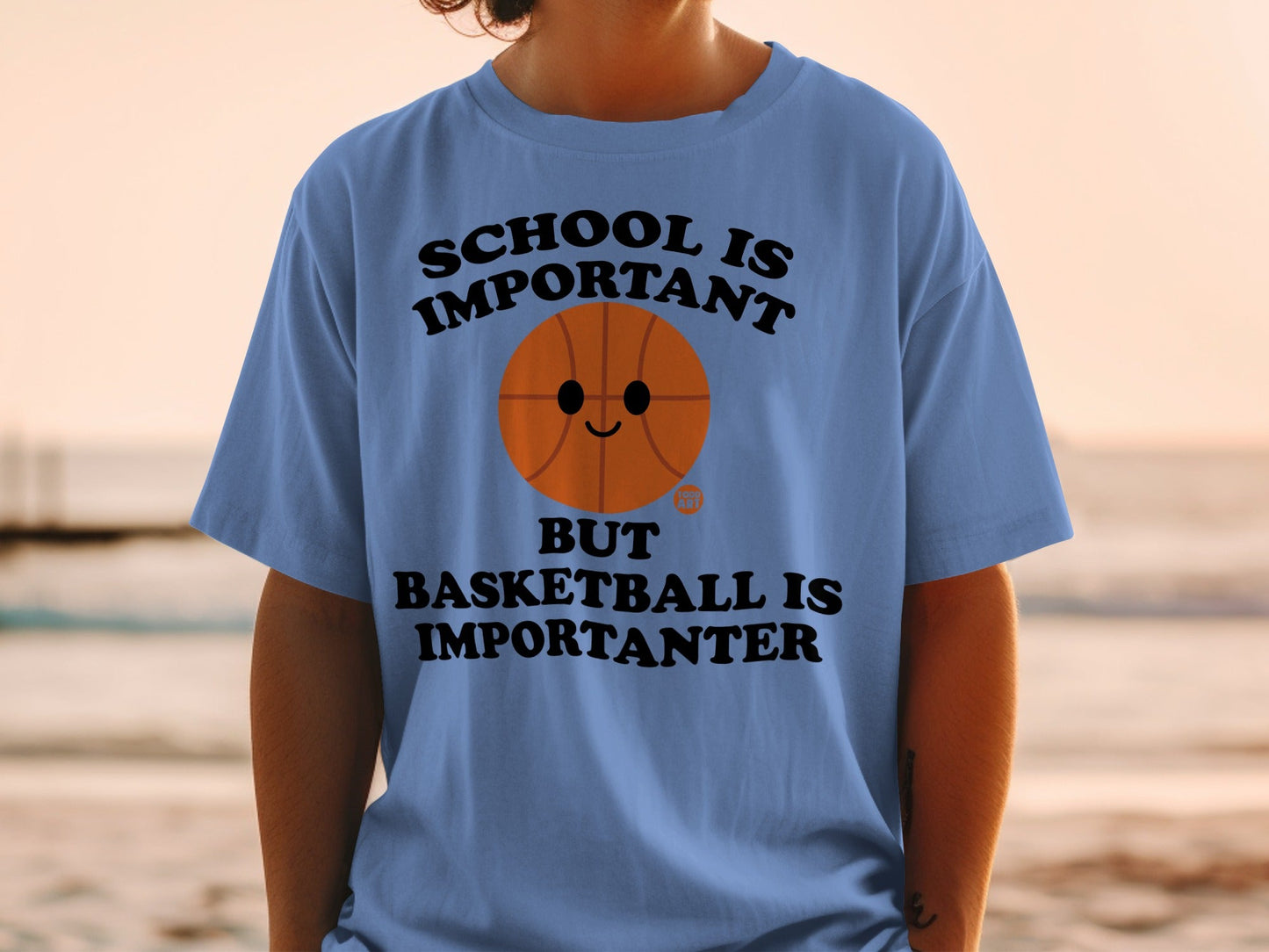 Blue t-shirt with a basketball graphic and text "SCHOOL IS IMPORTANT BUT BASKETBALL IS IMPORTANTER".