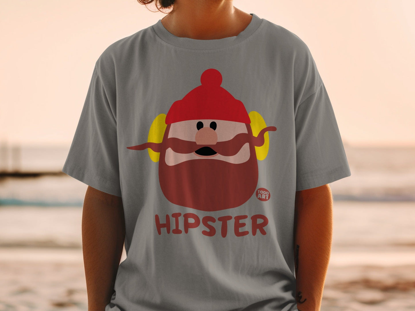 Gray t-shirt with a cartoon hipster face, red hat, and yellow earmuffs.