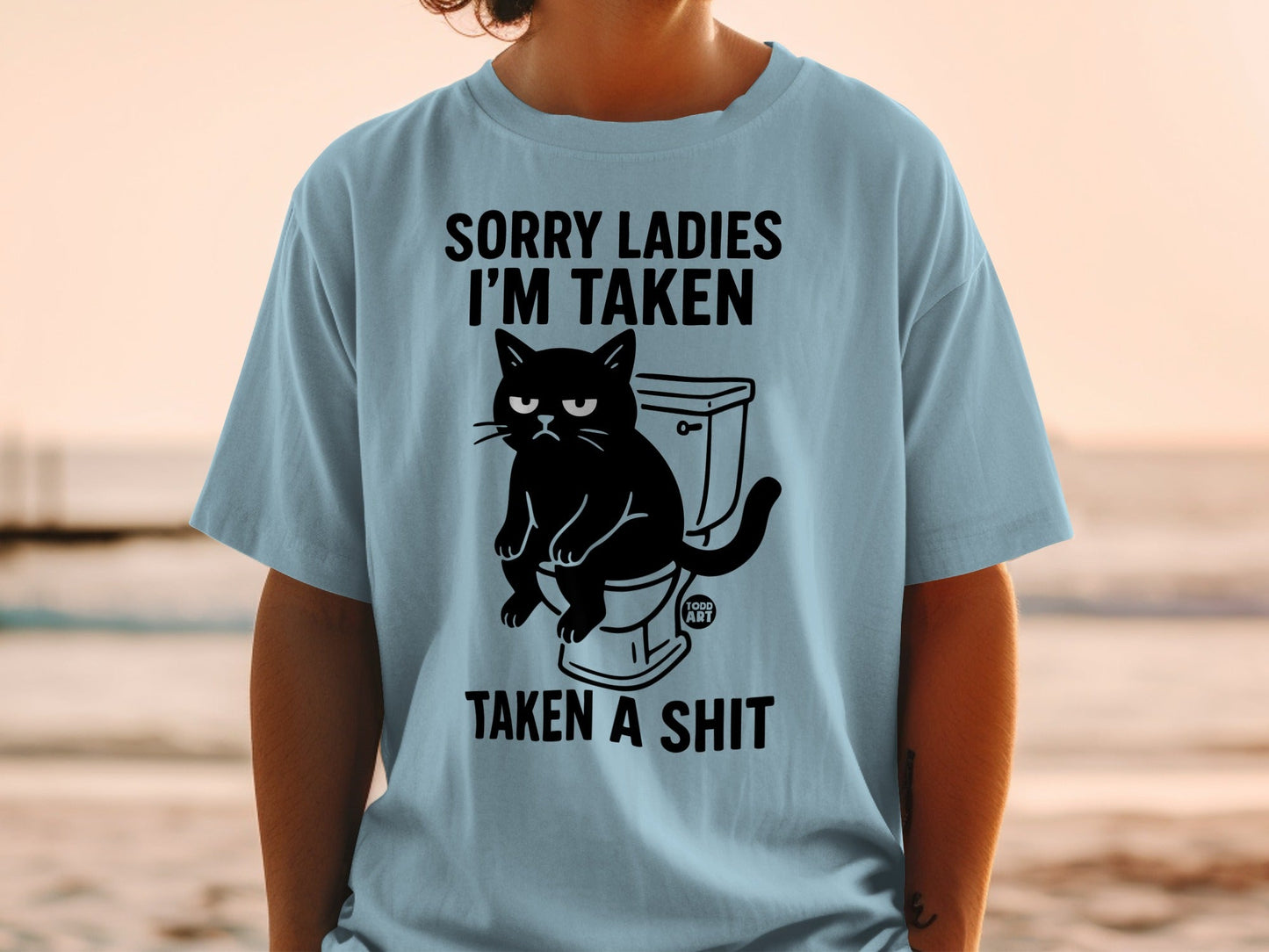 Black cat sitting on a toilet with text "SORRY LADIES I'M TAKEN TAKEN A SHIT".