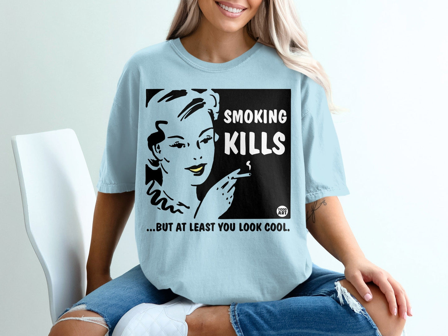 Light blue t-shirt with black and white comic art and text: "SMOKING KILLS ...BUT AT LEAST YOU LOOK COOL."