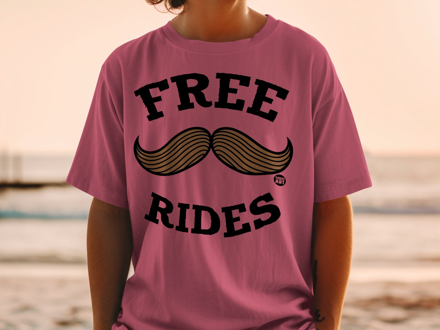 Pink t-shirt with "FREE RIDES" and a mustache graphic.