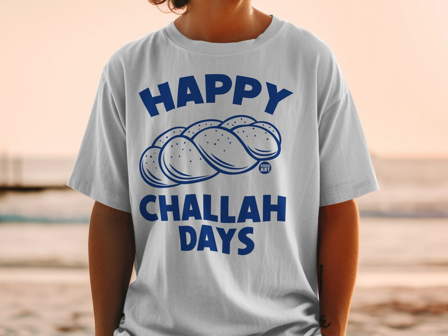 T-shirt with blue "Happy Challah Days" text and challah bread illustration.