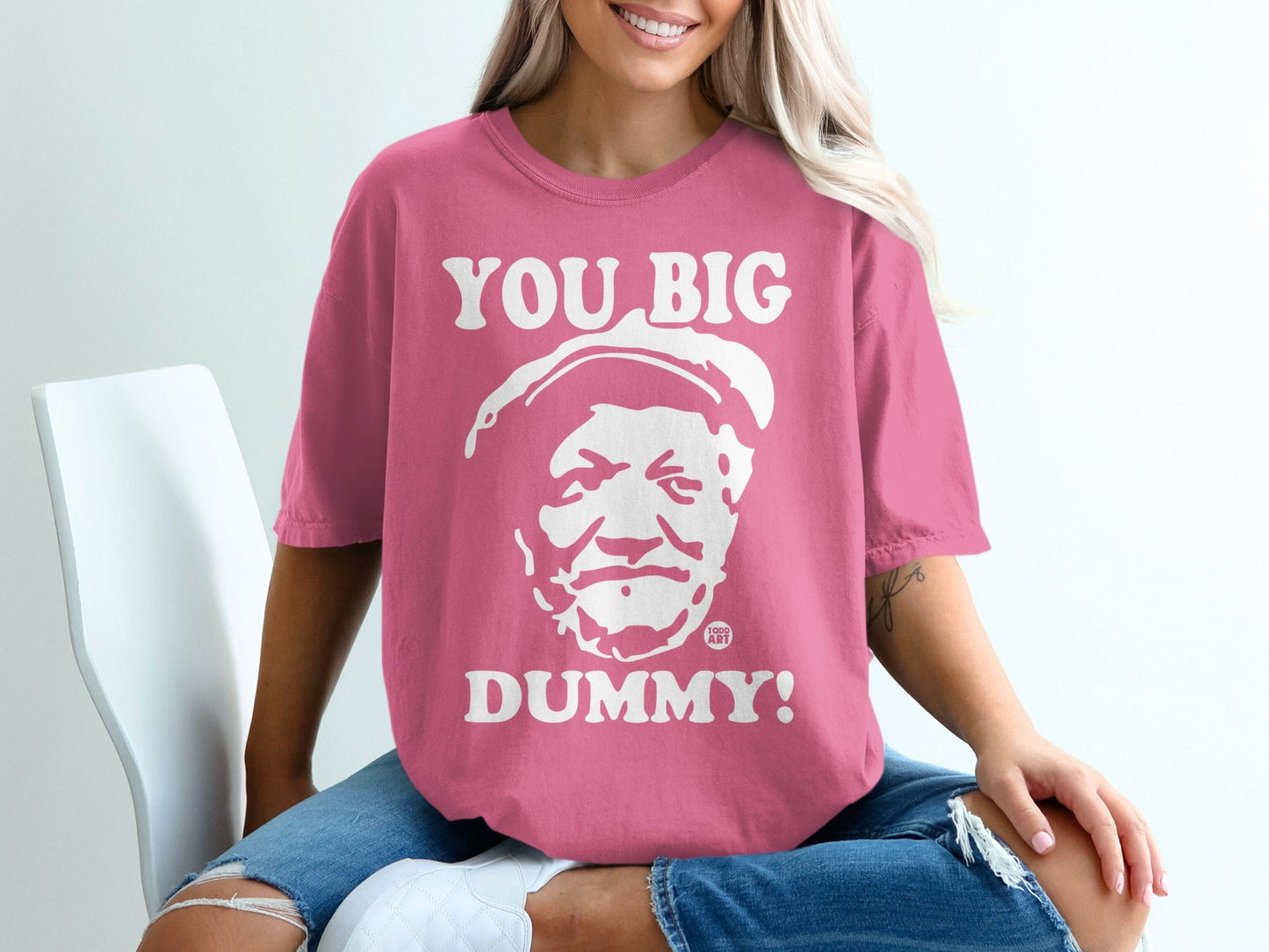 Pink t-shirt with "YOU BIG DUMMY!" graphic and a portrait.