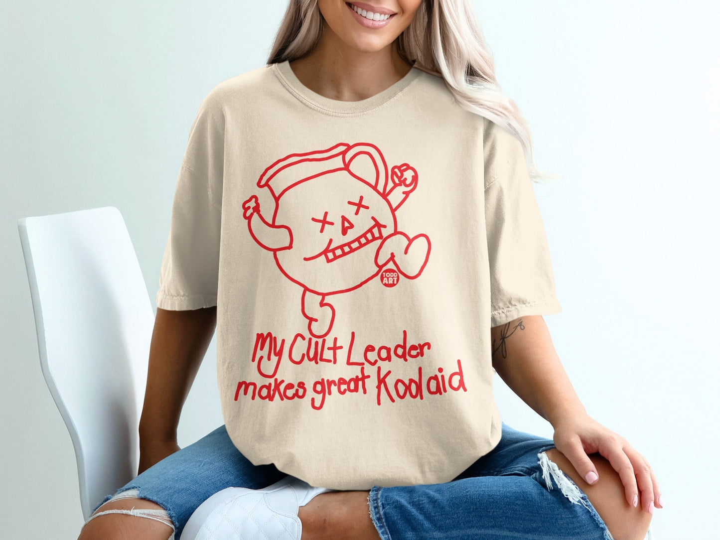 Cream t-shirt with red Kool-Aid Man graphic and "My cult leader makes great koolaid" text.