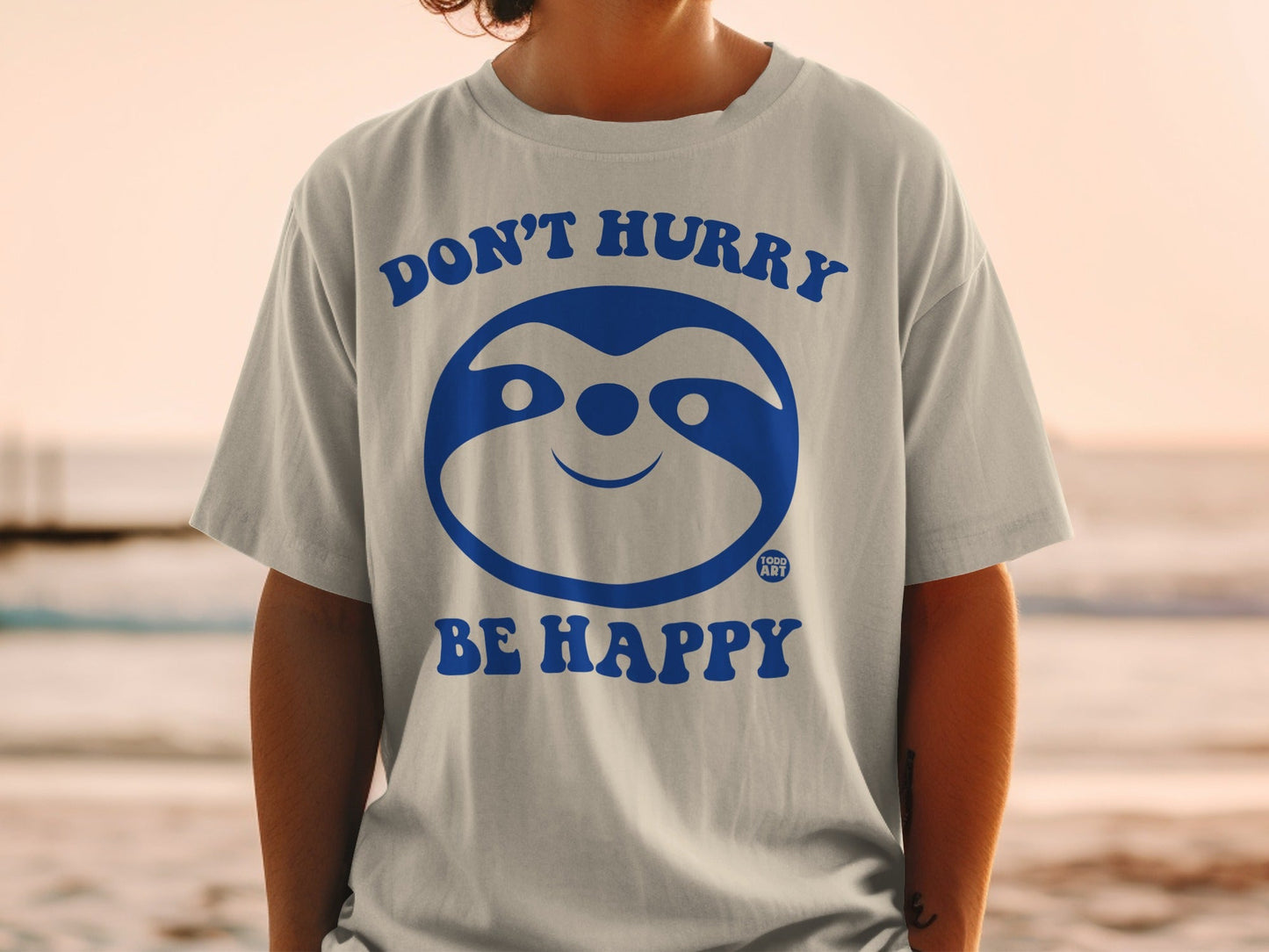 Gray t-shirt with blue sloth graphic and text "DON'T HURRY BE HAPPY."