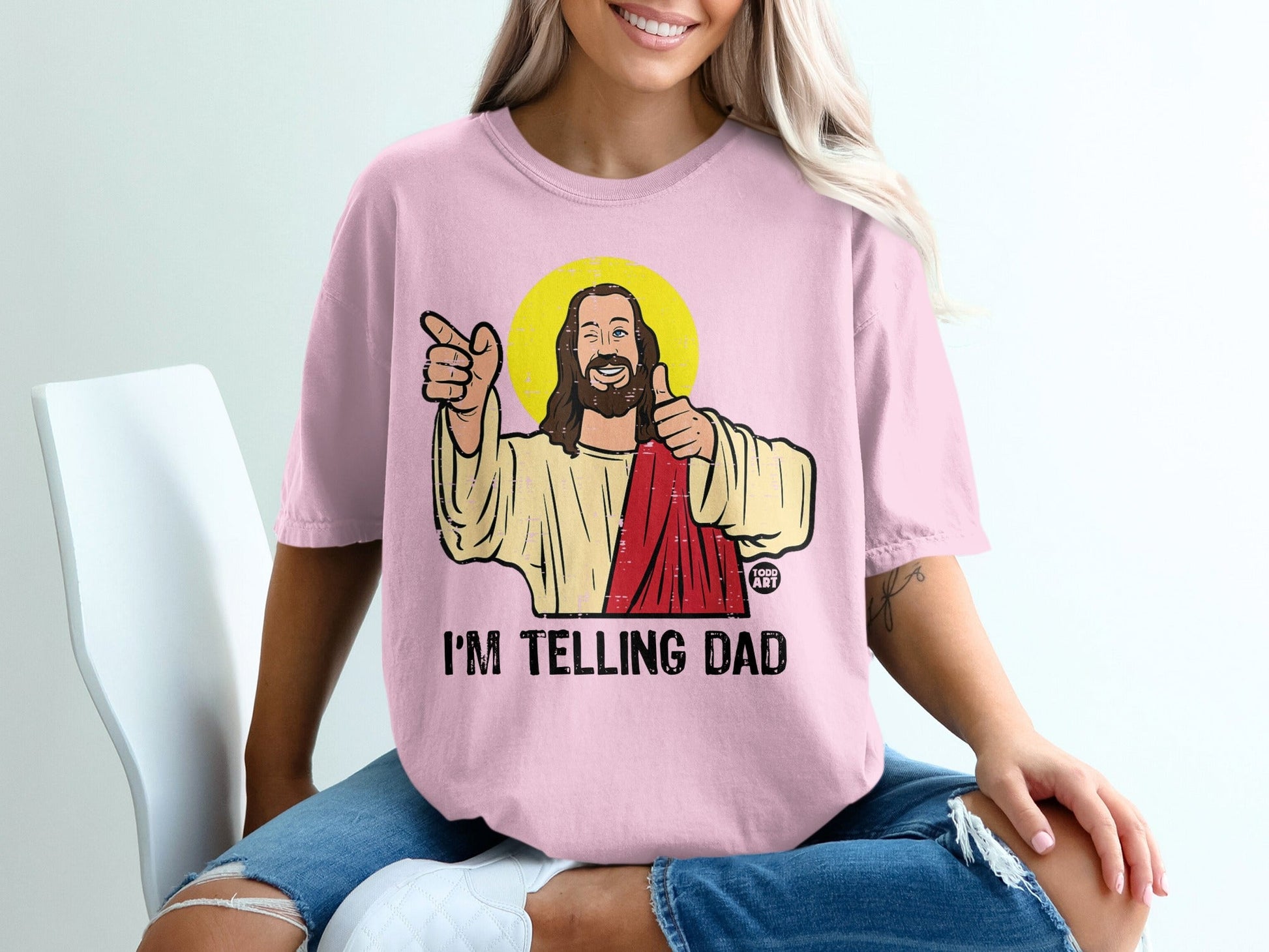 Pink t-shirt with Jesus graphic and "I'm Telling Dad" text.