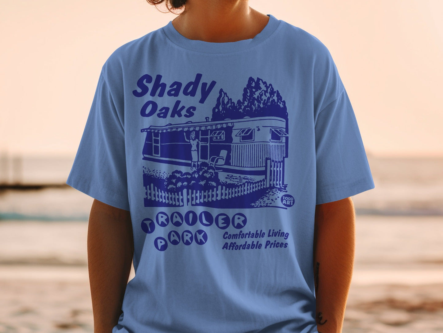 Blue t-shirt with "Shady Oaks Trailer Park" text and illustration.