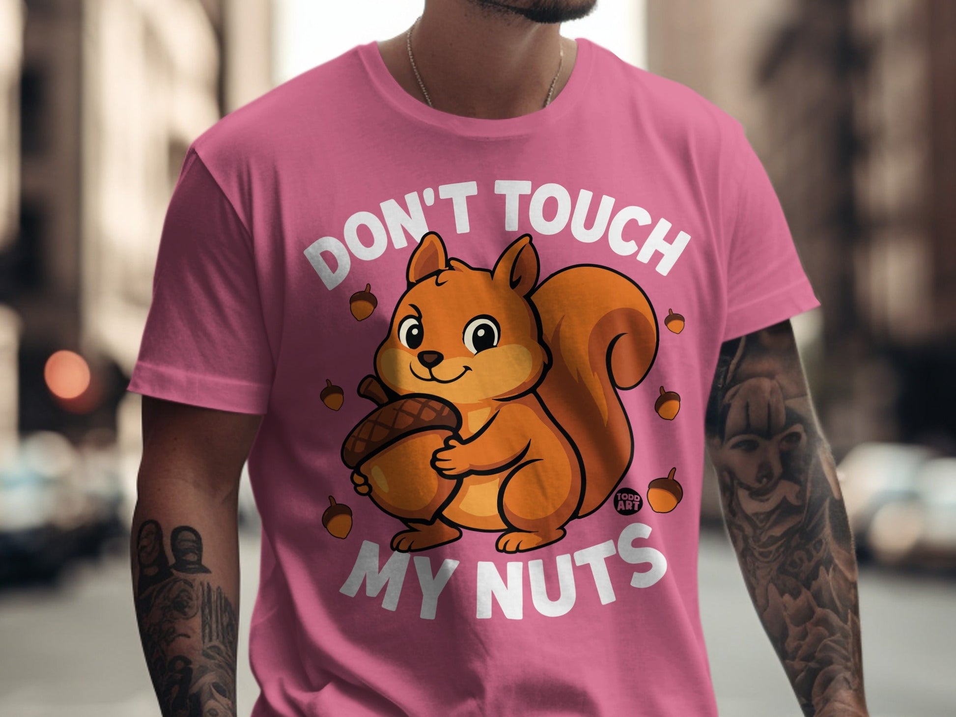 Pink t-shirt with cartoon squirrel holding acorn and text "DON'T TOUCH MY NUTS".