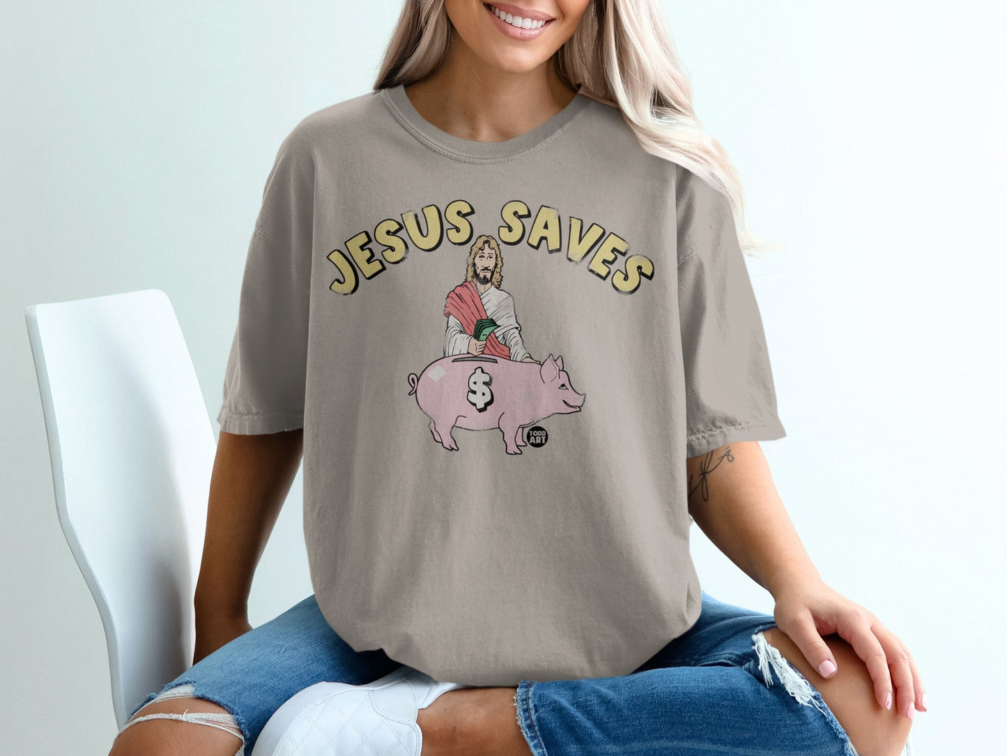 T-shirt with Jesus sitting on a pig, text "Jesus Saves".