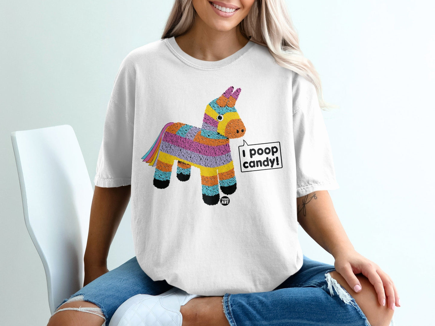 White t-shirt with a colorful striped pi√±ata graphic saying "I poop candy!".