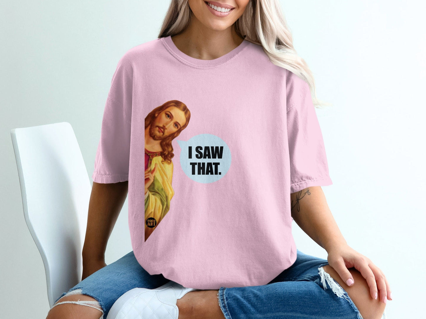 Pink t-shirt with "I SAW THAT." speech bubble and Jesus illustration.