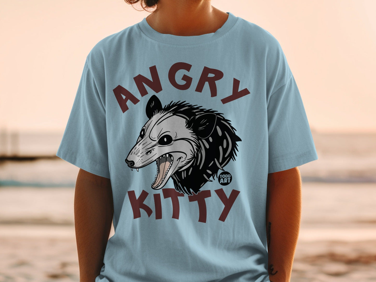 Light blue t-shirt with "ANGRY KITTY" and a stylized possum head.