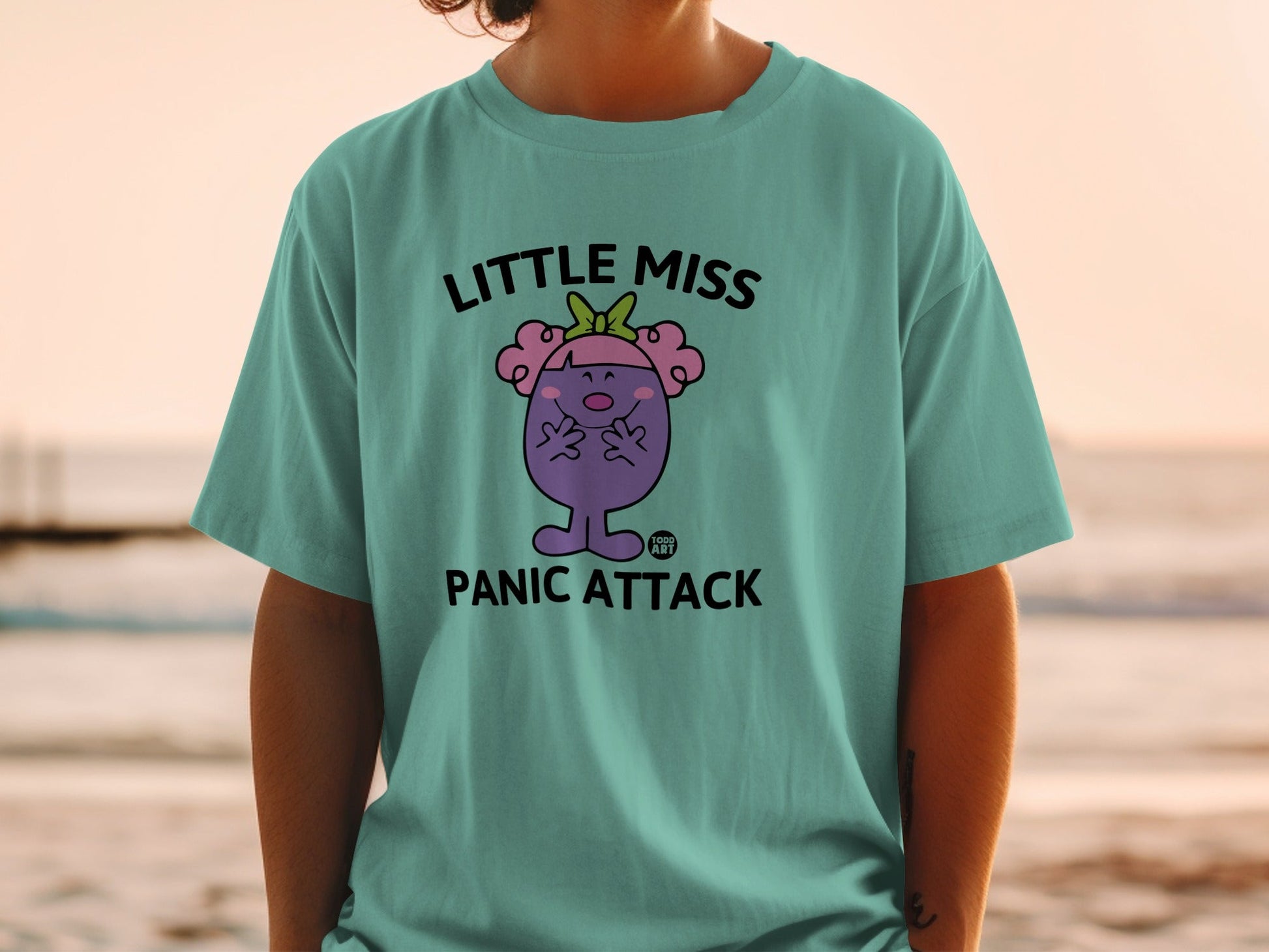 Teal t-shirt with "Little Miss Panic Attack" text and cartoon character.