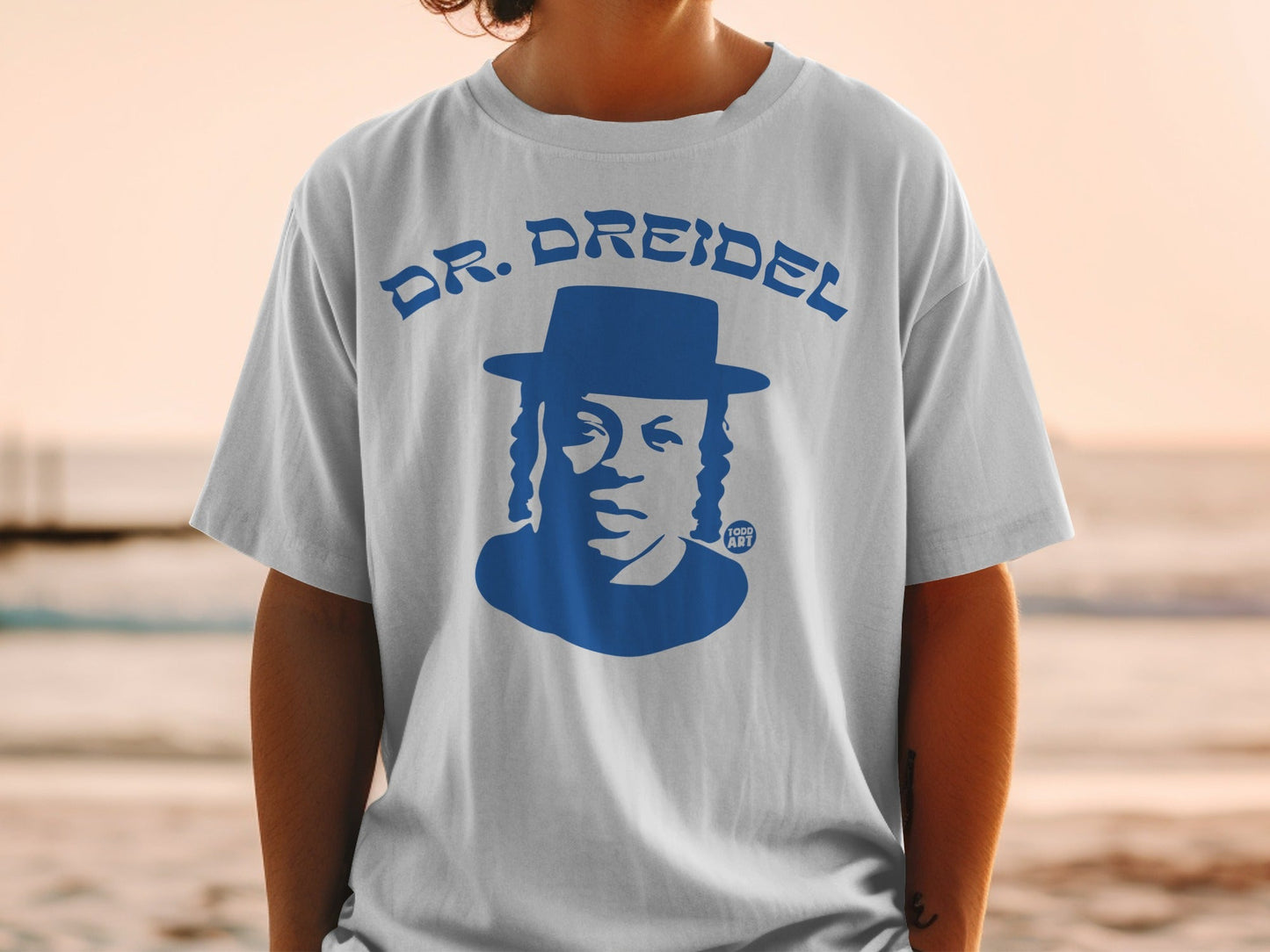 White t-shirt with blue Dr. Dreidel graphic and text.