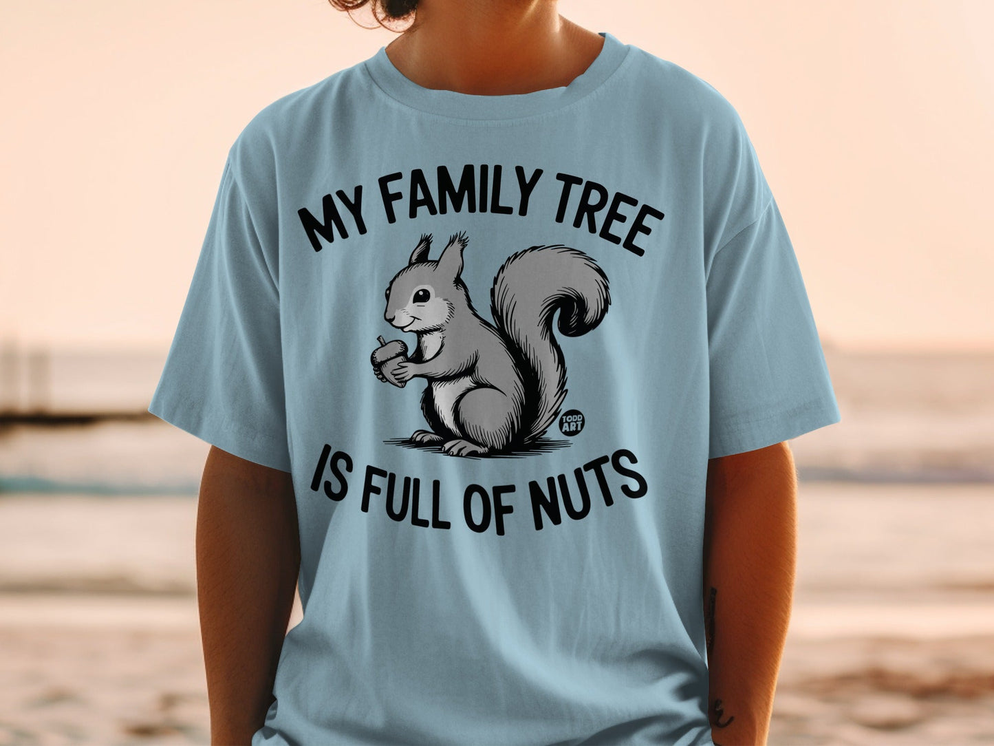 Light blue t-shirt with a squirrel holding an acorn and text "MY FAMILY TREE IS FULL OF NUTS".