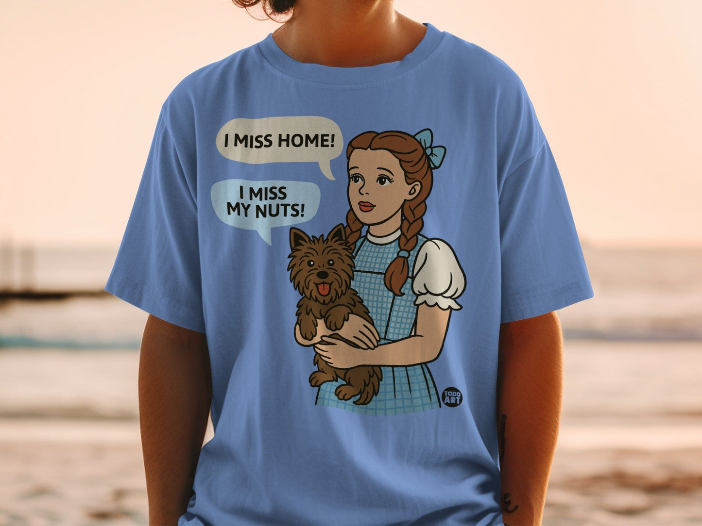 Dorothy holding Toto, with speech bubbles saying "I miss home!" and "I miss my nuts!".