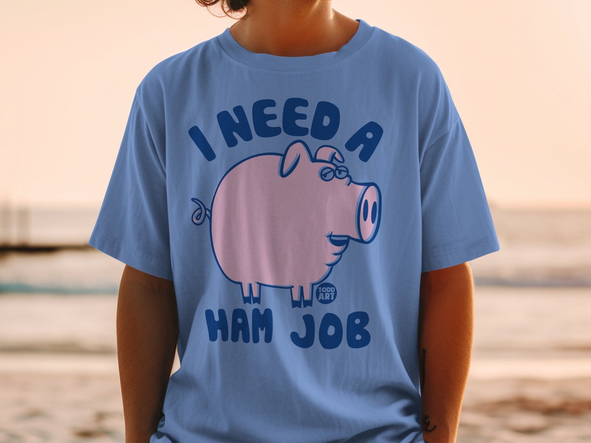 Blue t-shirt with cartoon pig wearing glasses, text "I NEED A HAM JOB".