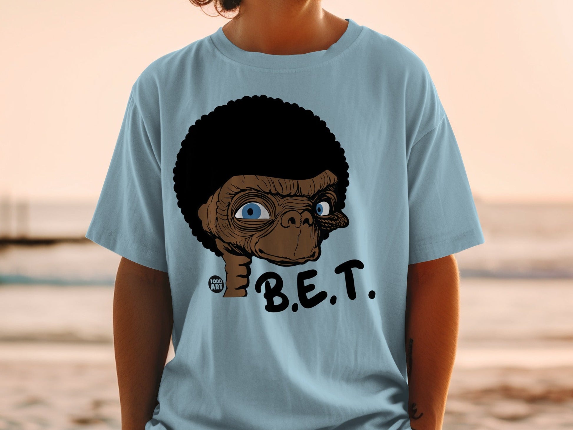 Light blue t-shirt with cartoon ET character and B.E.T. text.