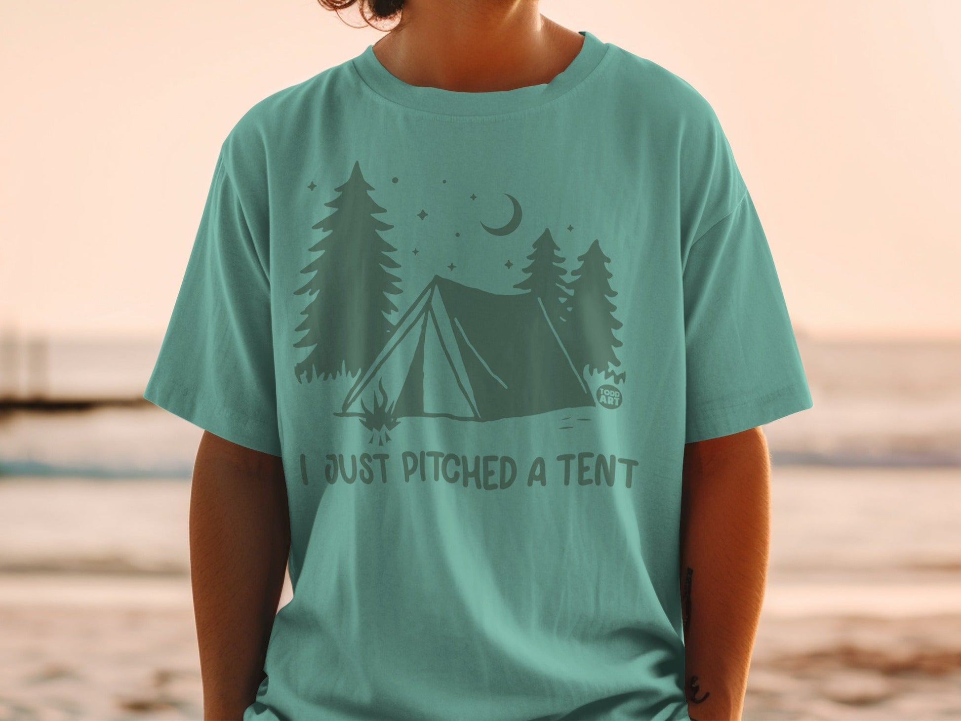 Teal t-shirt with a graphic of a tent, trees, and moon, reading "I just pitched a tent."