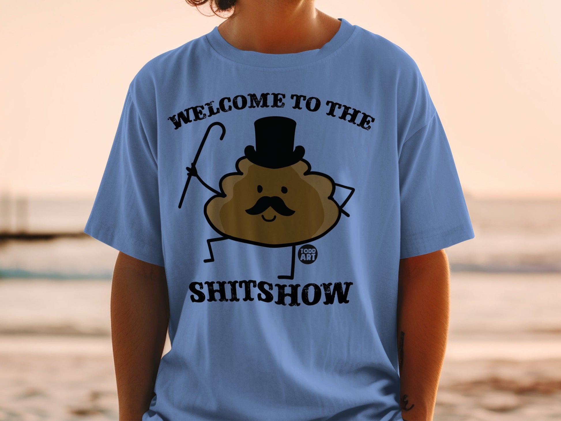 T-shirt with cartoon poop character wearing top hat and holding cane, text "Welcome to the Shitshow".