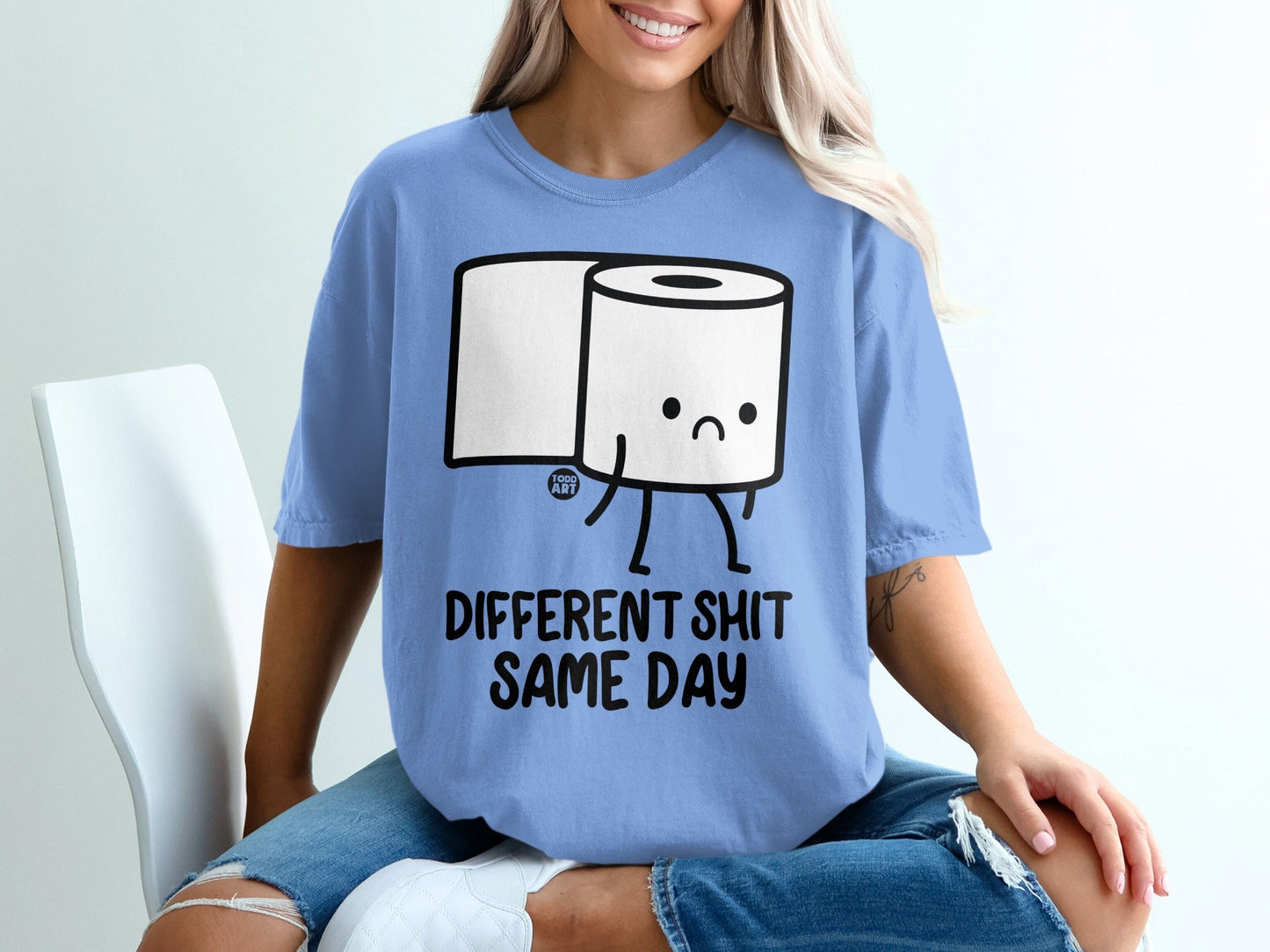 Blue t-shirt with a sad toilet paper roll graphic and text "DIFFERENT SHIT SAME DAY".