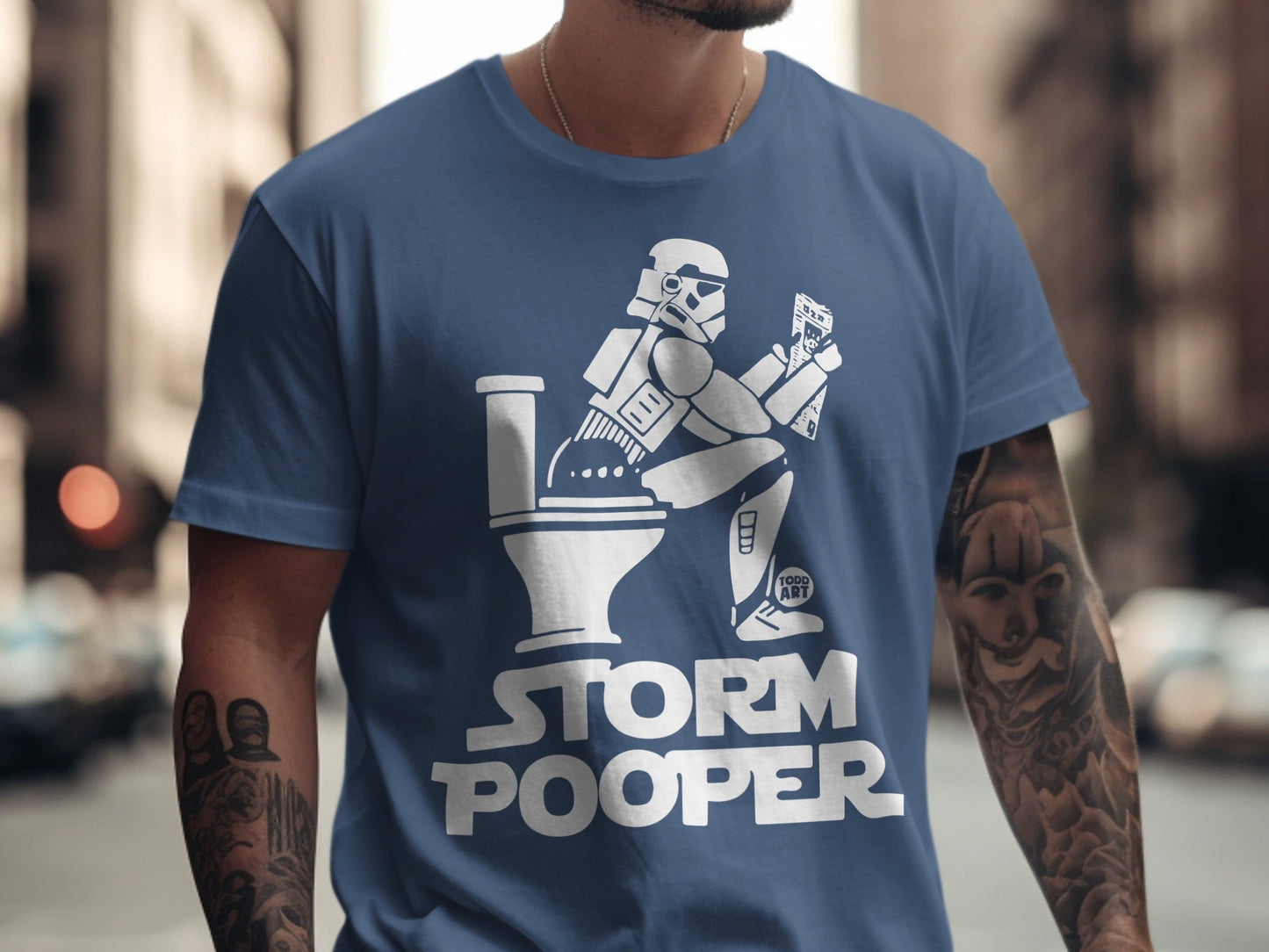 Stormtrooper on toilet with "Storm Pooper" text on blue t-shirt.