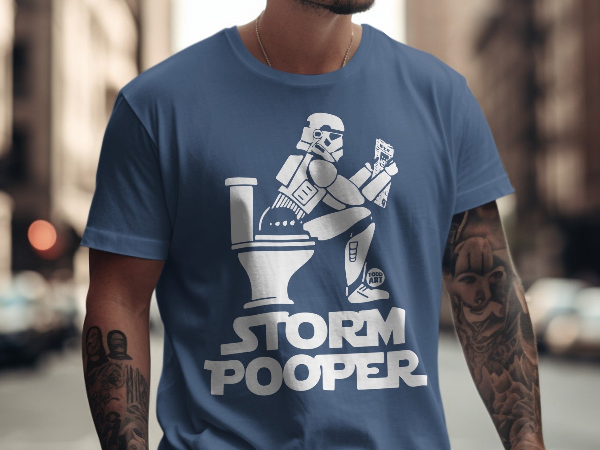 Stormtrooper on toilet with "Storm Pooper" text on blue t-shirt.