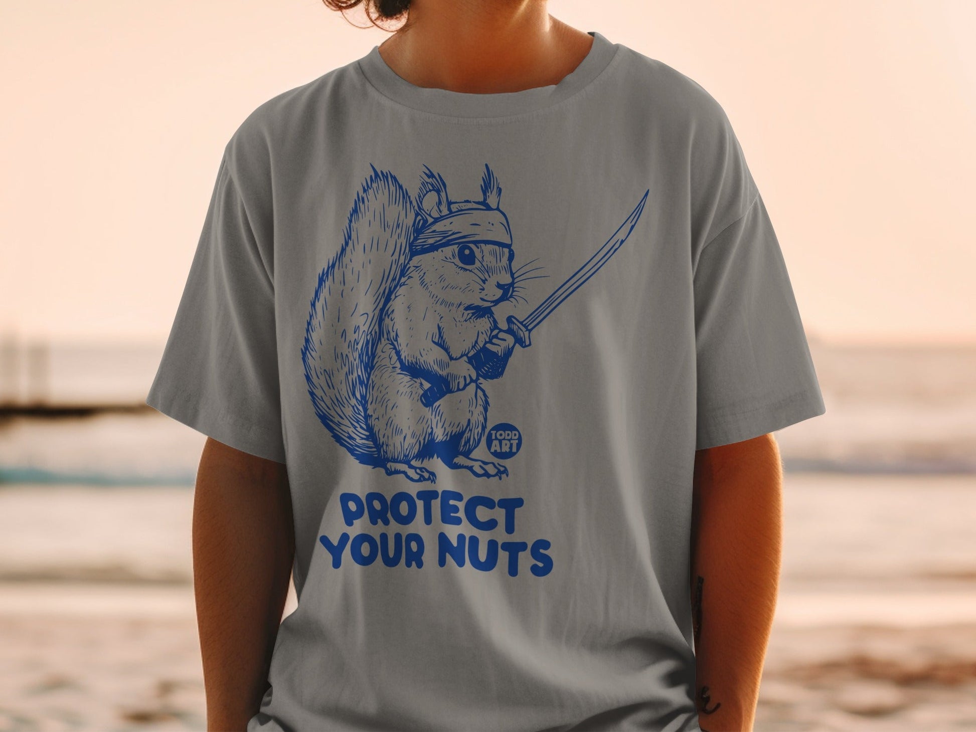 Squirrel warrior with sword and headband, "Protect Your Nuts" text.