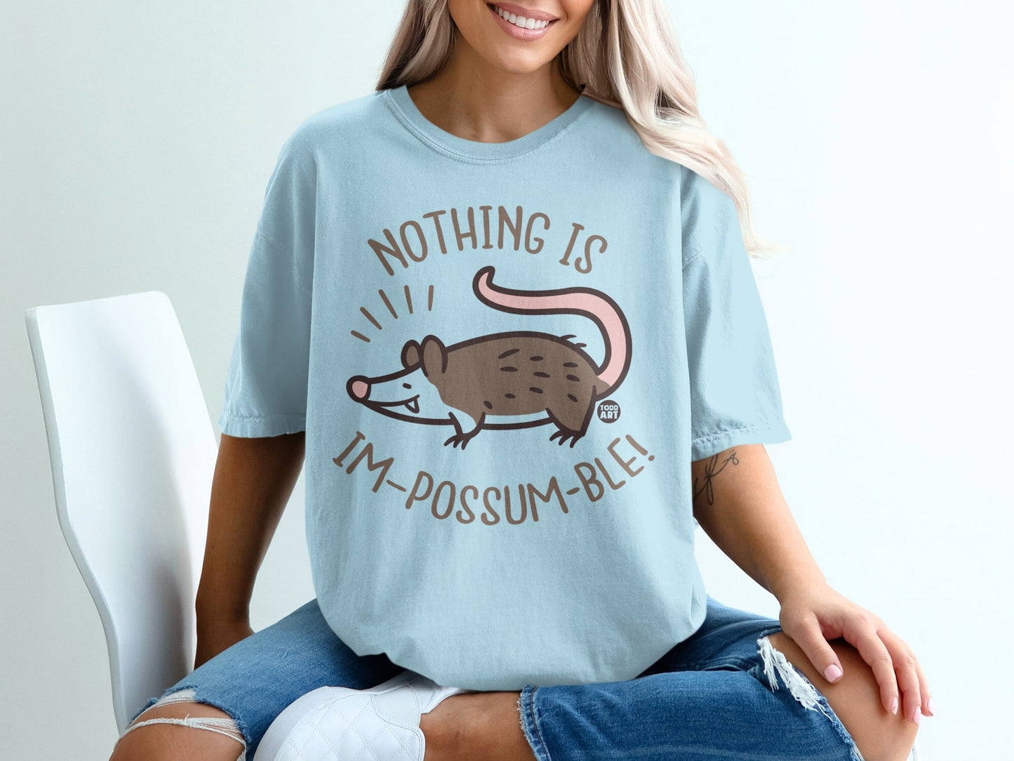 Light blue t-shirt with "Nothing is Im-possum-ble!" text and a cartoon opossum.