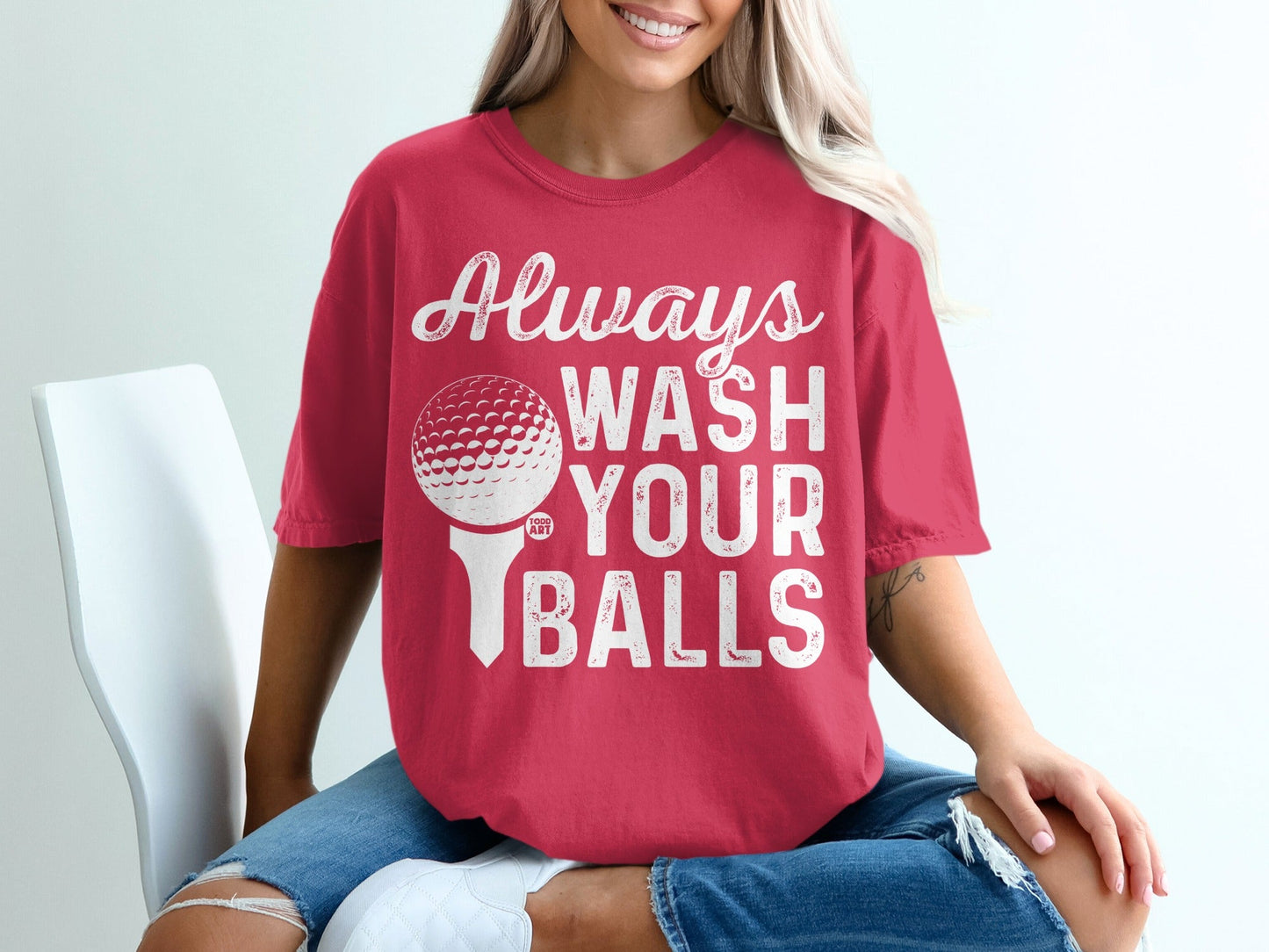 Woman wearing red t-shirt with "Always Wash Your Balls" and golf ball graphic.