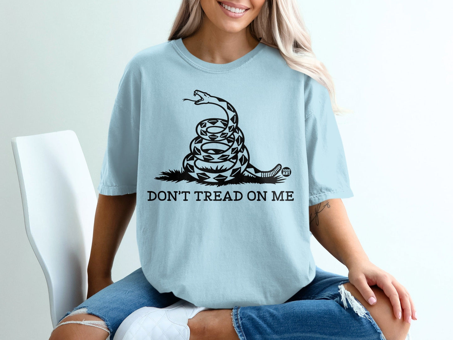 Light blue t-shirt with coiled snake and "Don't Tread on Me" text.