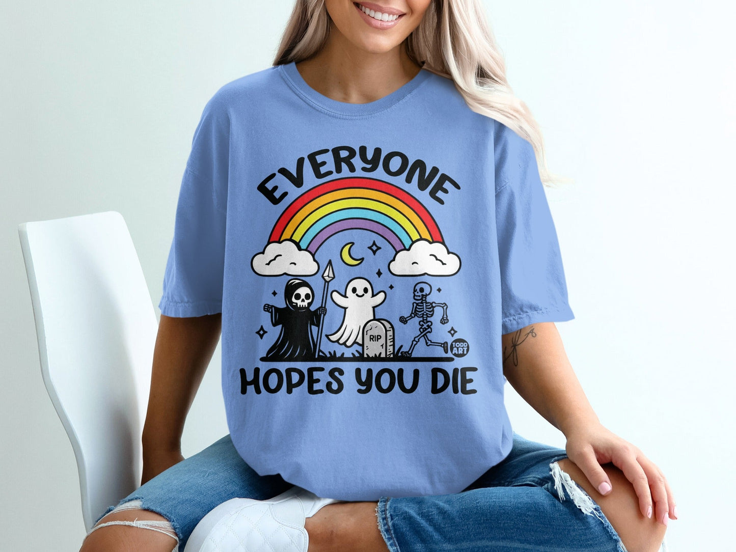 Blue t-shirt with rainbow, ghost, skeleton, and text: EVERYONE HOPES YOU DIE.
