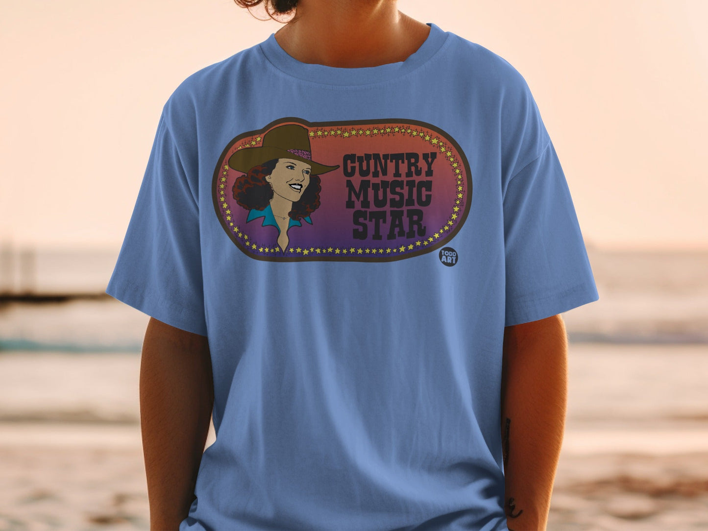 Blue t-shirt with oval graphic featuring a smiling woman and "Country Music Star" text.
