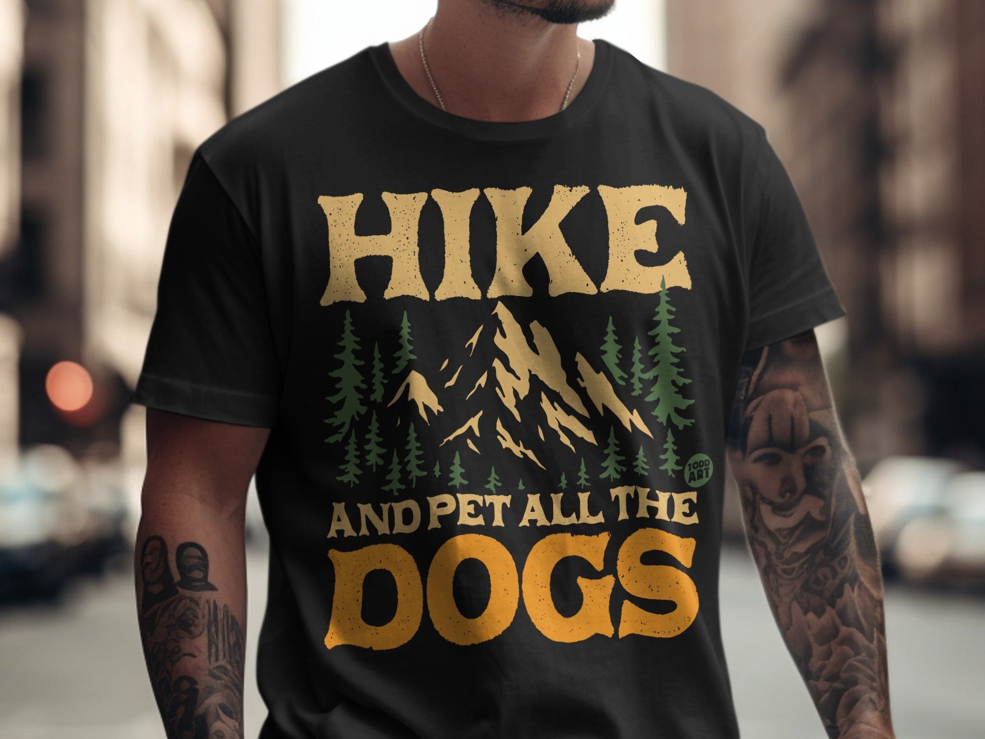 Black t-shirt with "Hike and Pet All the Dogs" text and mountain graphic.