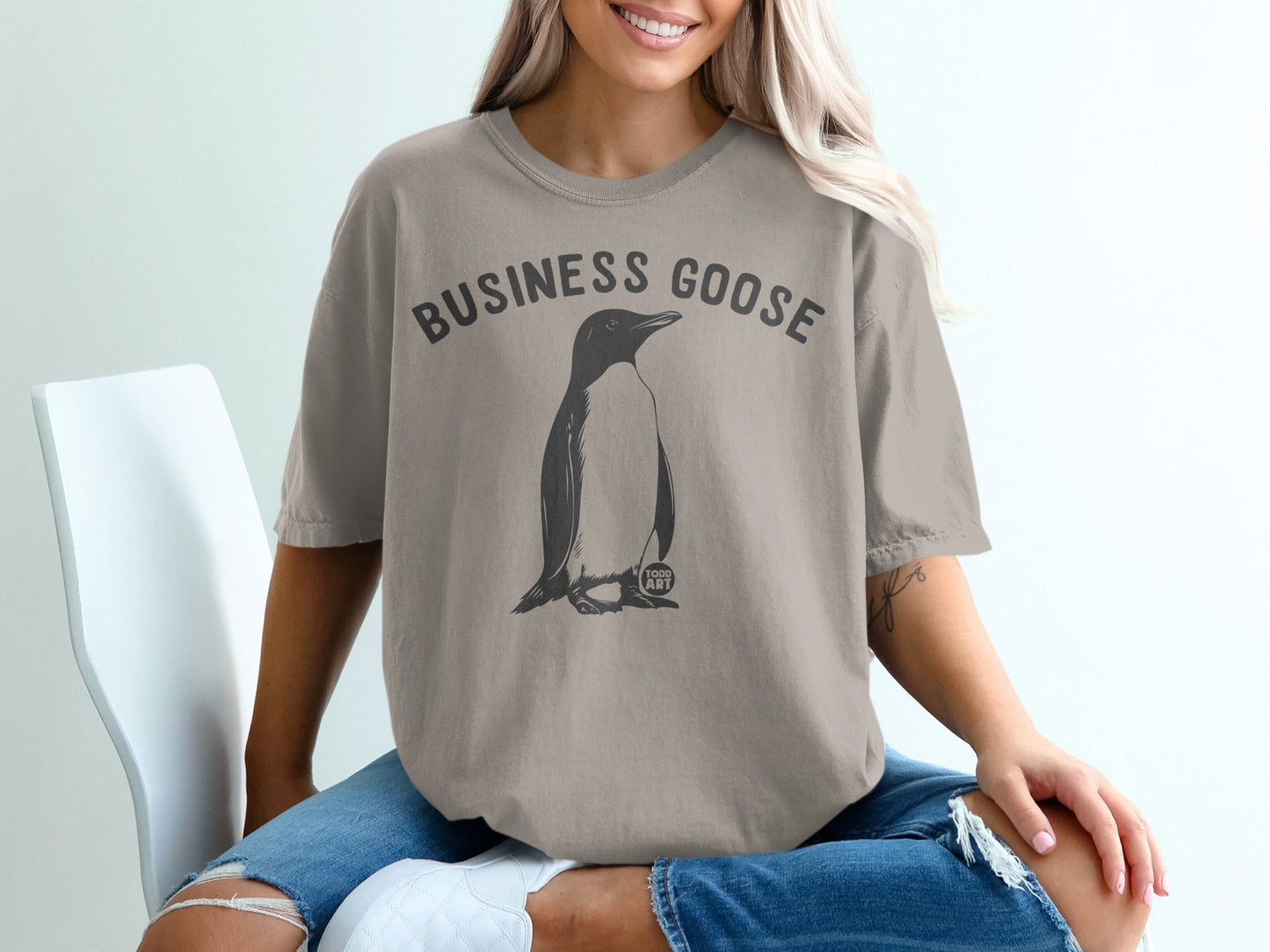 T-shirt with a penguin graphic and "BUSINESS GOOSE" text.