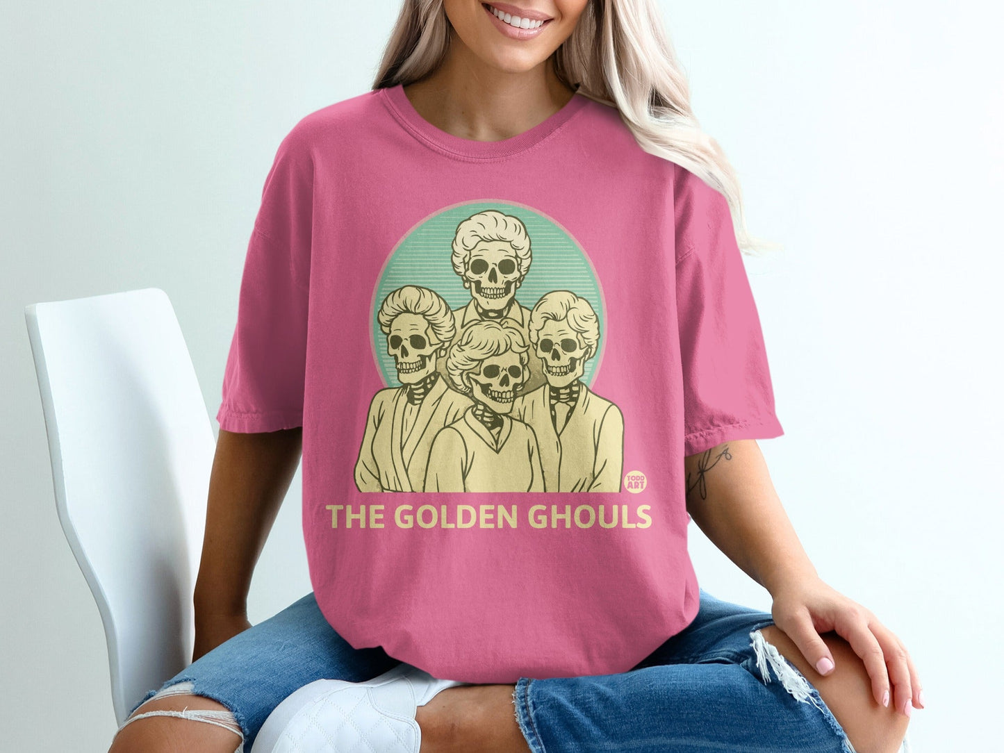 Pink t-shirt with "The Golden Ghouls" text and four skeleton heads.