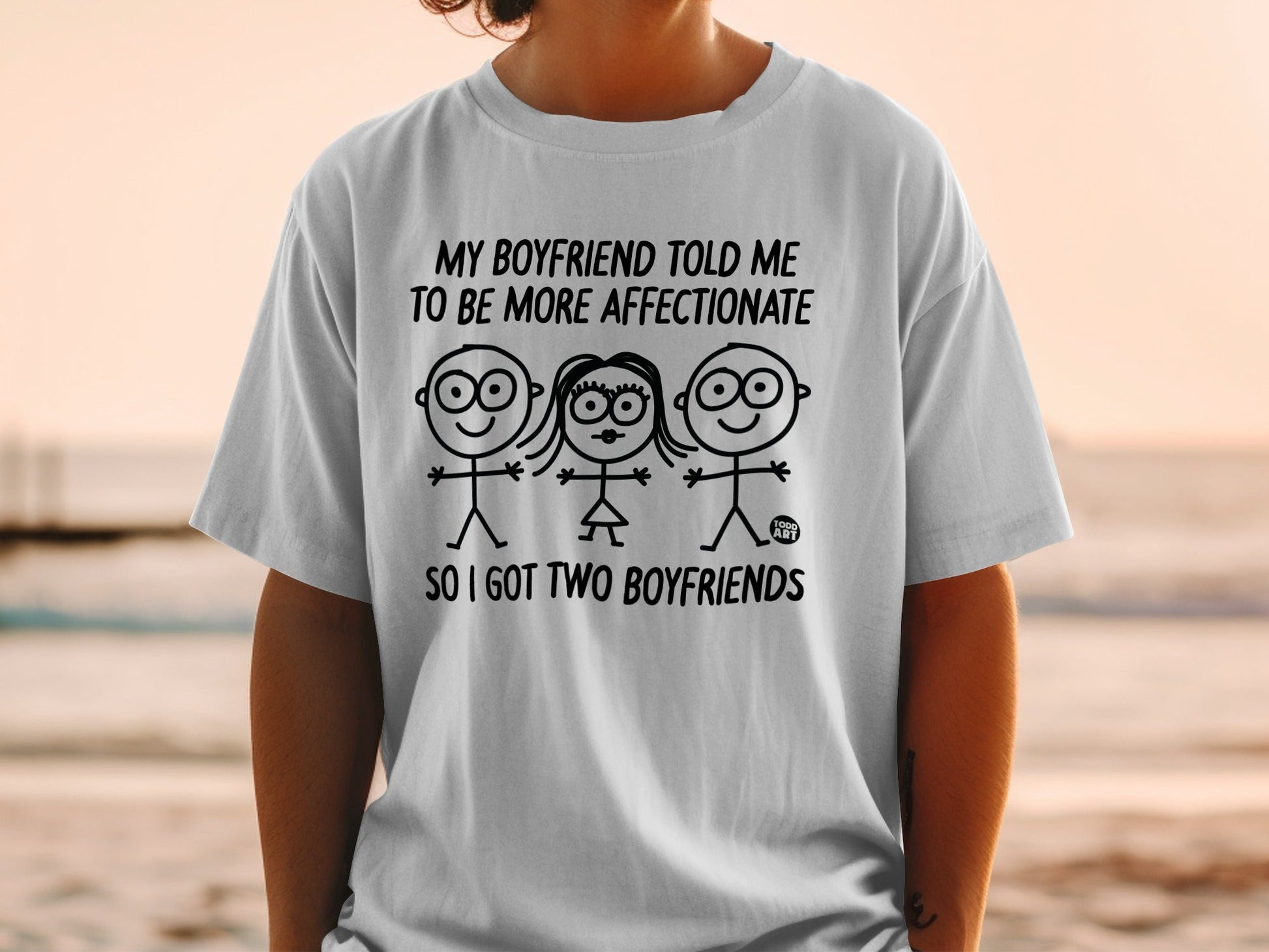 T-shirt with text "My boyfriend told me to be more affectionate so I got two boyfriends" and stick figures.