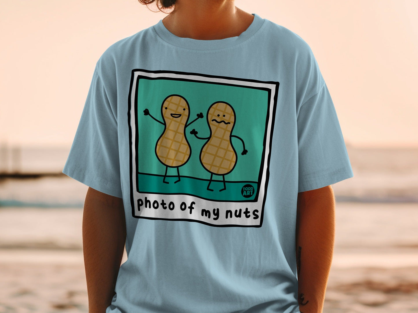 Blue t-shirt with cartoon peanuts smiling in a frame.