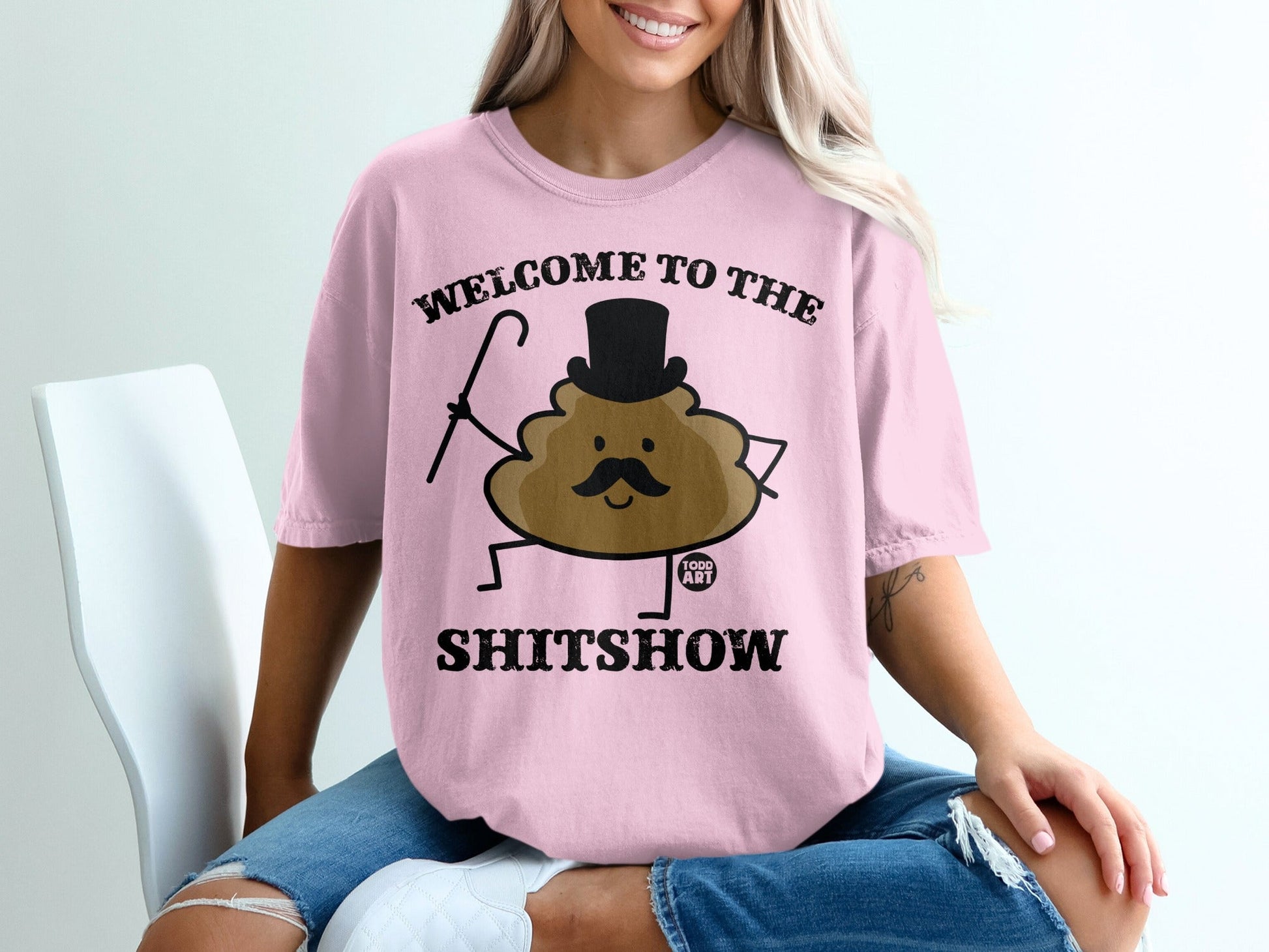 Pink t-shirt with "Welcome to the Shitshow" text and a cartoon poop character.