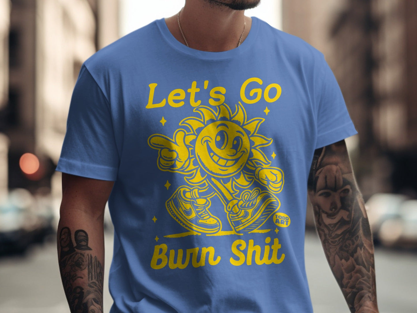 Blue t-shirt with yellow cartoon sun graphic and text "Let's Go Burn Shit".