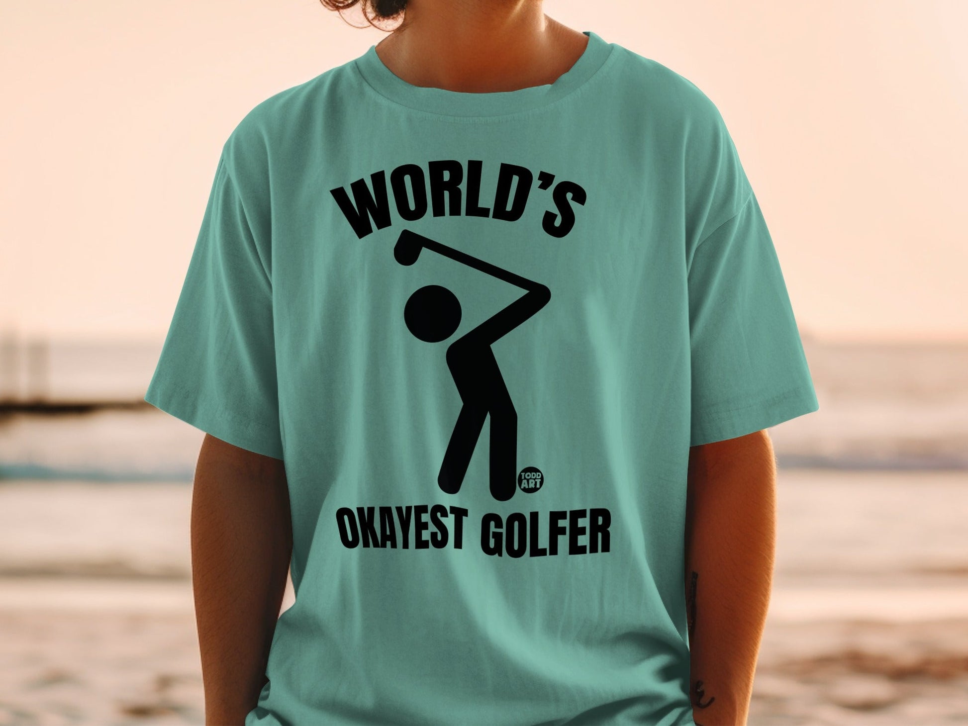 T-shirt with black graphic of a golfer and text "WORLD'S OKAYEST GOLFER".