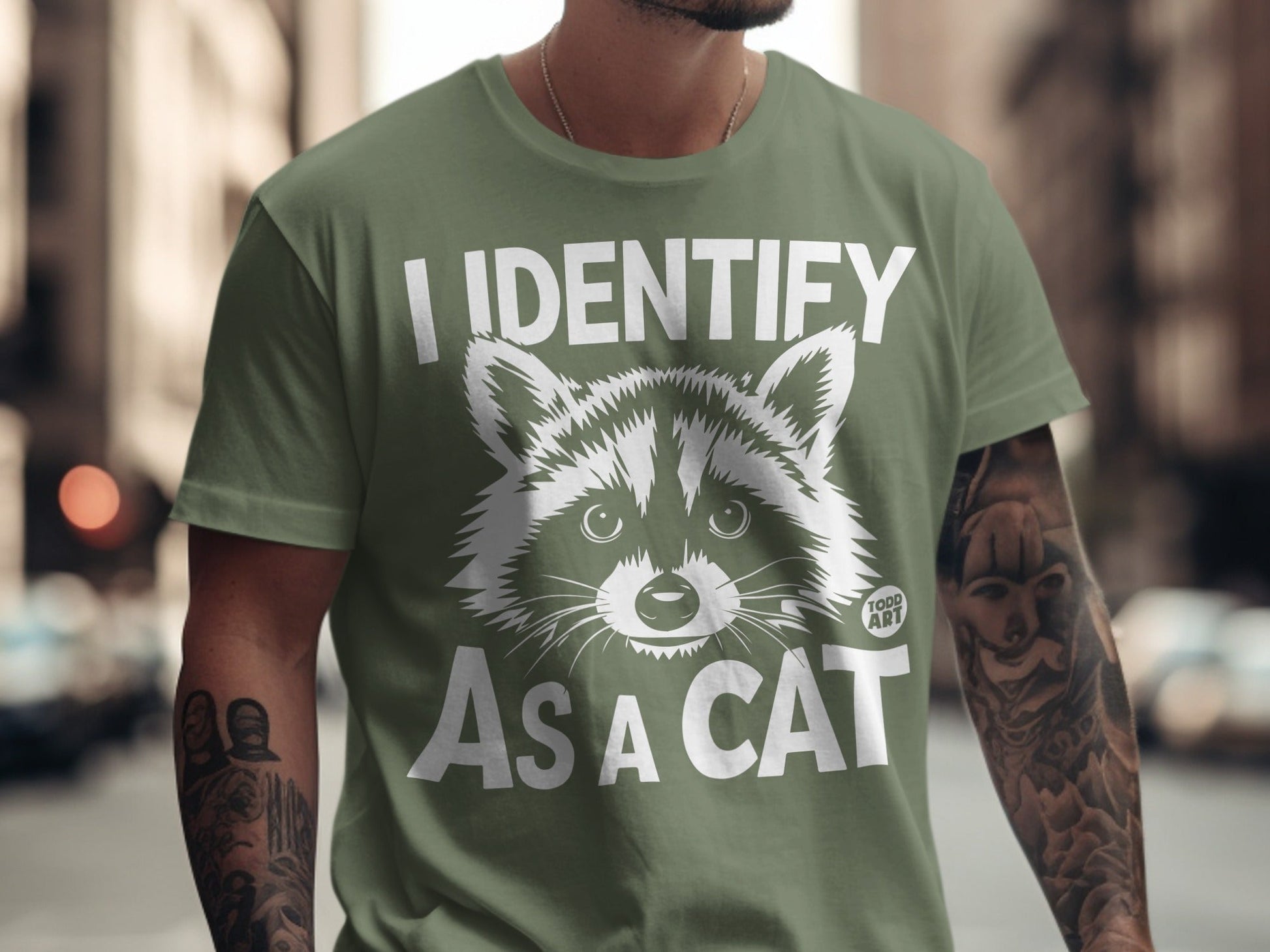 Green t-shirt with "I IDENTIFY AS A CAT" and raccoon graphic.