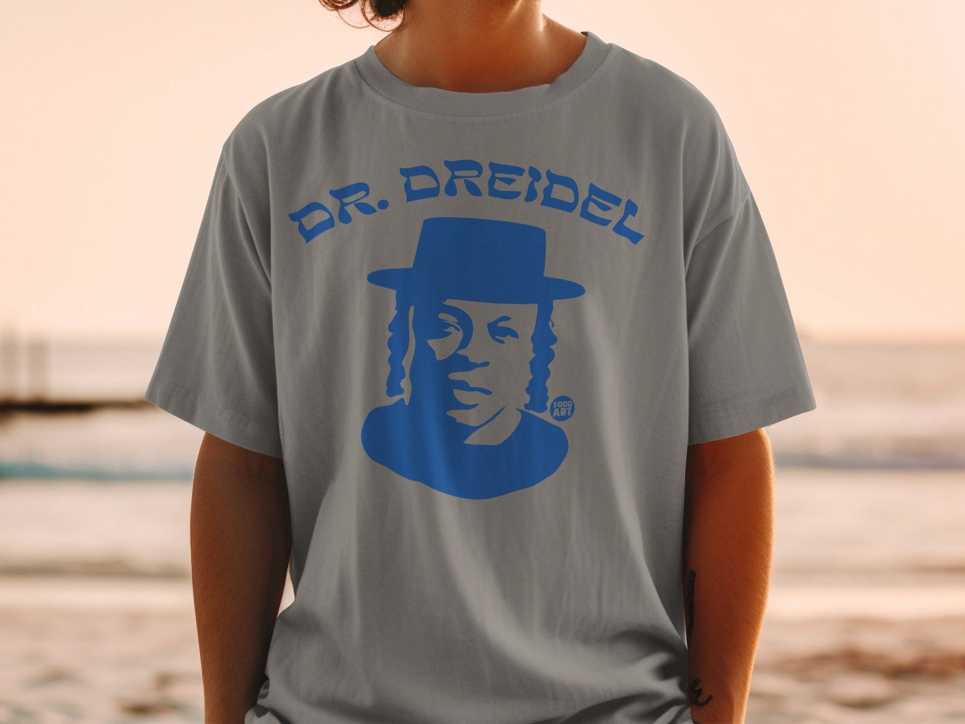 T-shirt with blue silhouette of a man in a hat and "DR. DREIDEL" text.