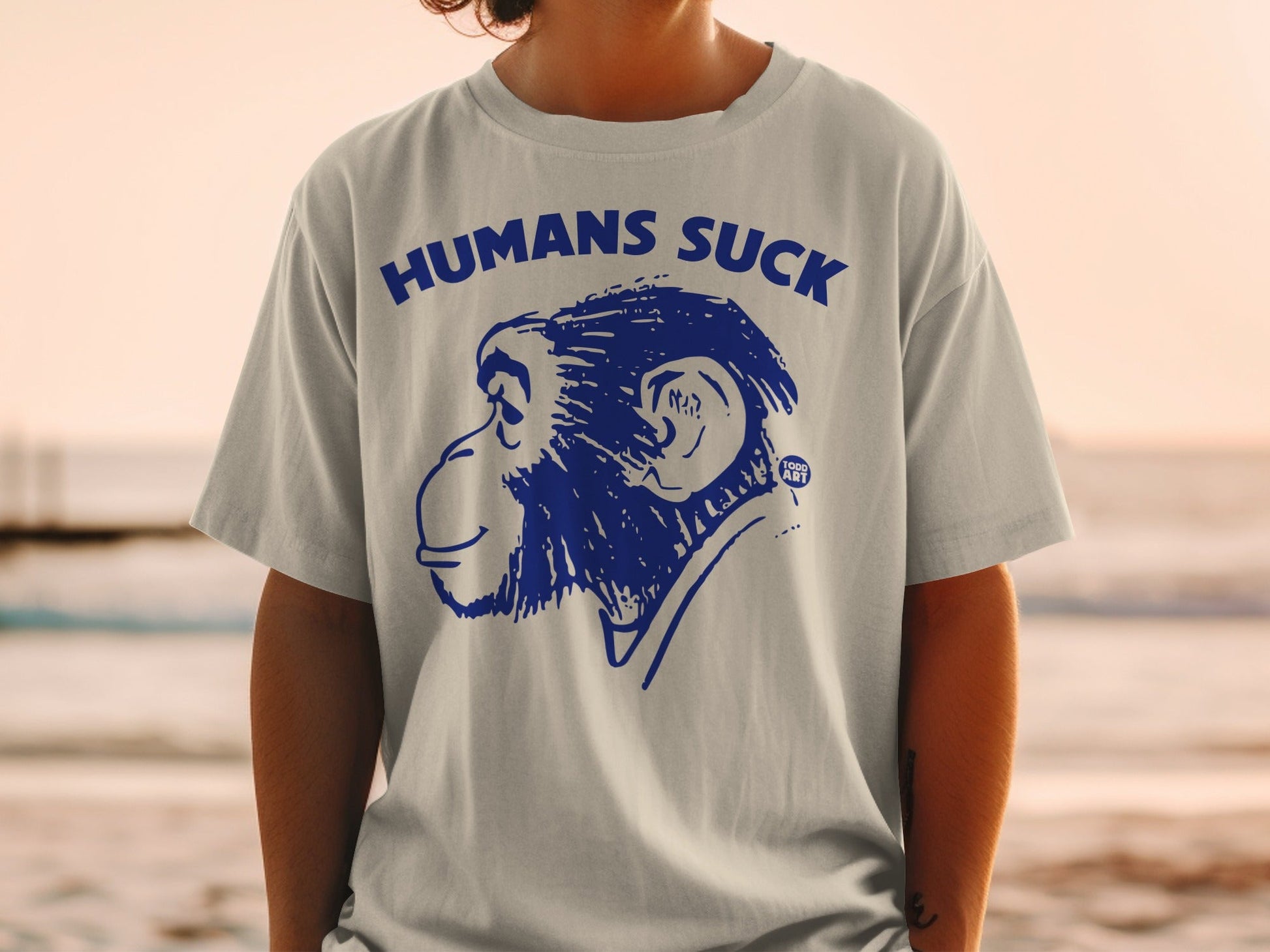 Grey t-shirt with blue graphic of a monkey and text "HUMANS SUCK".