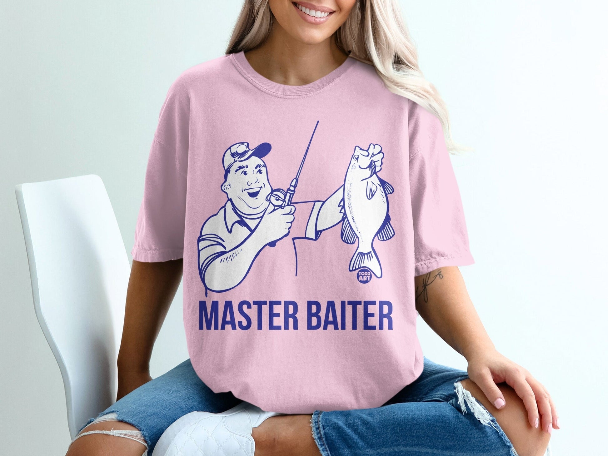 Pink t-shirt with cartoon angler holding fish, text "MASTER BAITER".