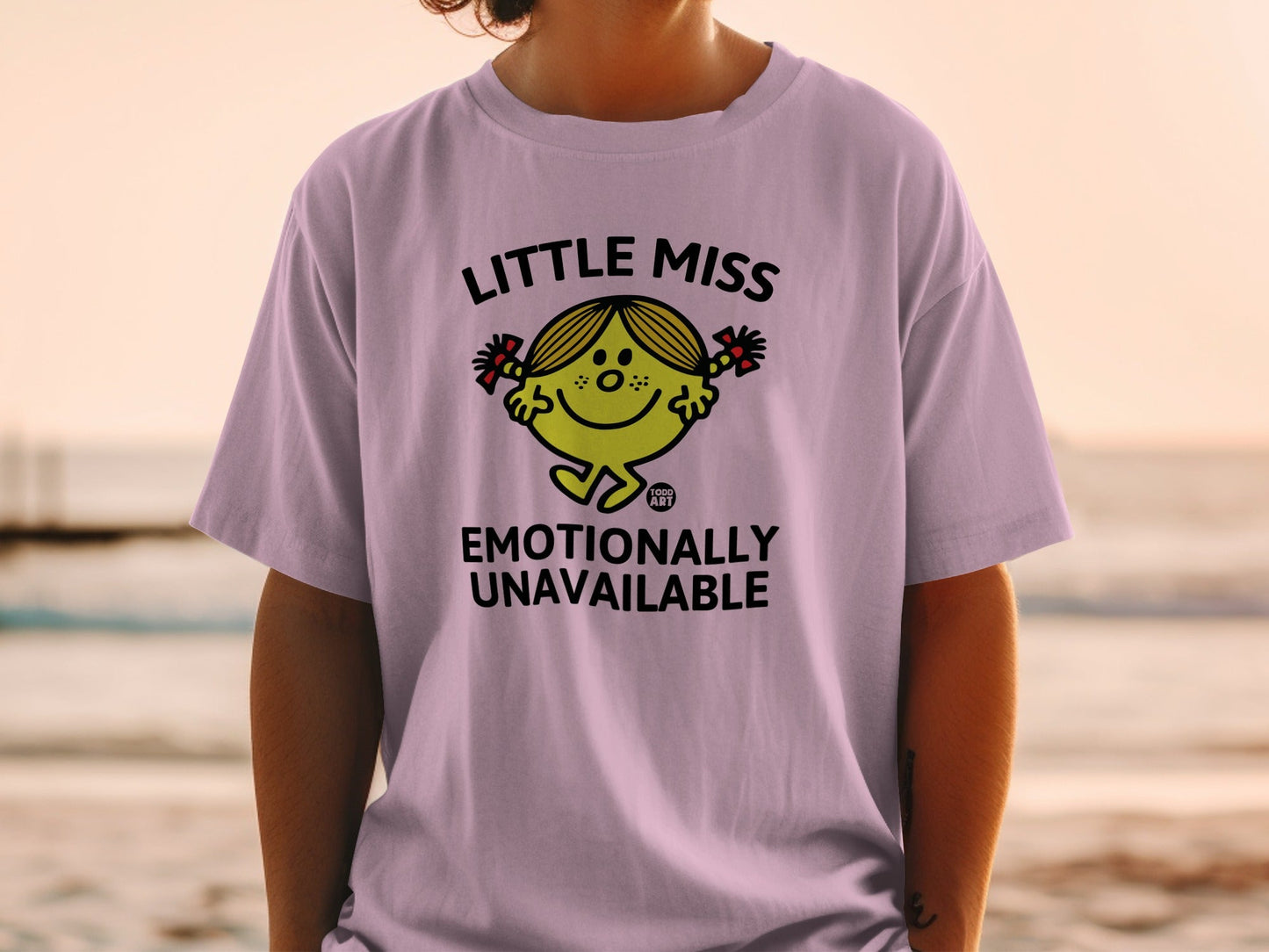Light purple t-shirt with "Little Miss Emotionally Unavailable" text and character.